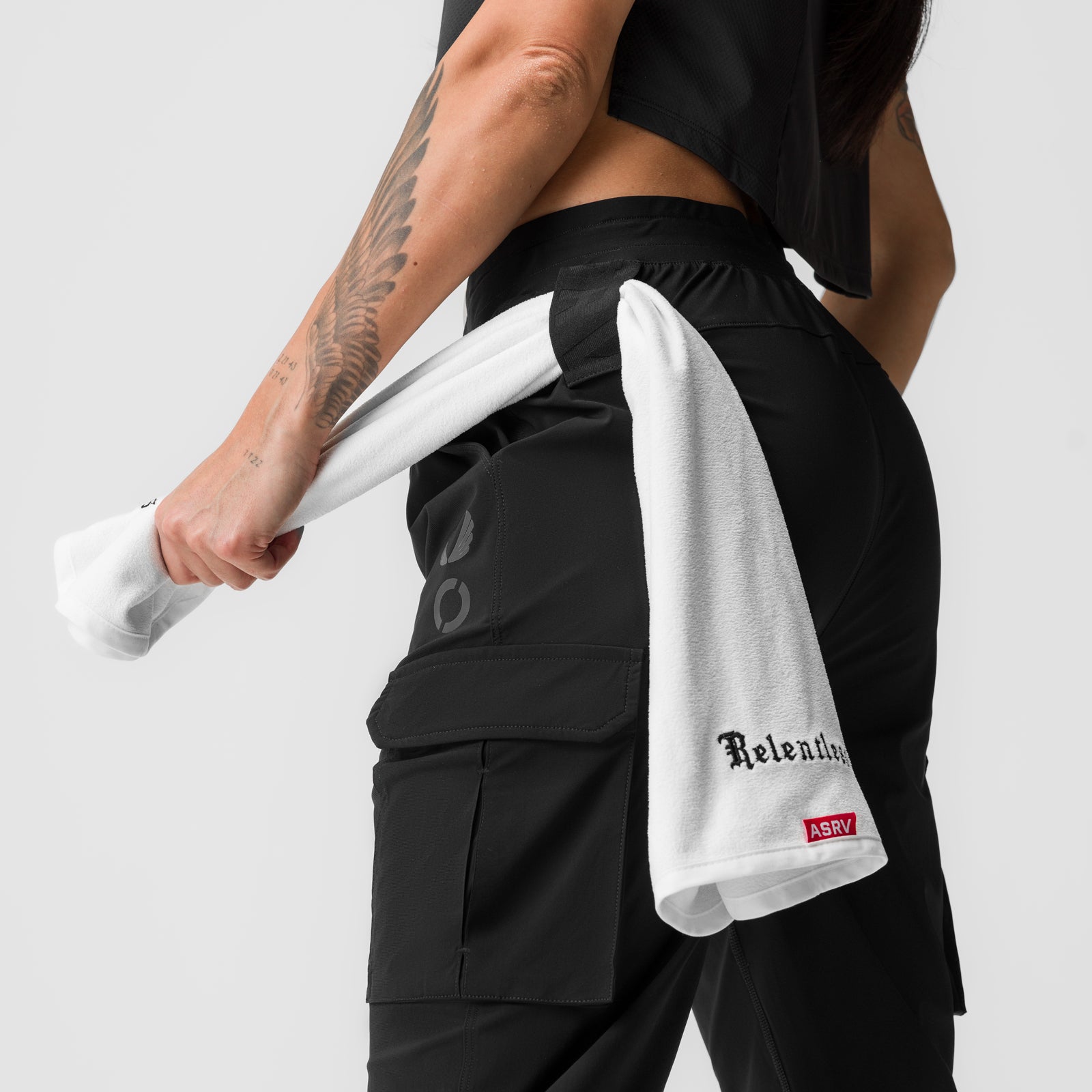 Black Tetra-Lite cargo jogger worn by model holding white towel, side view