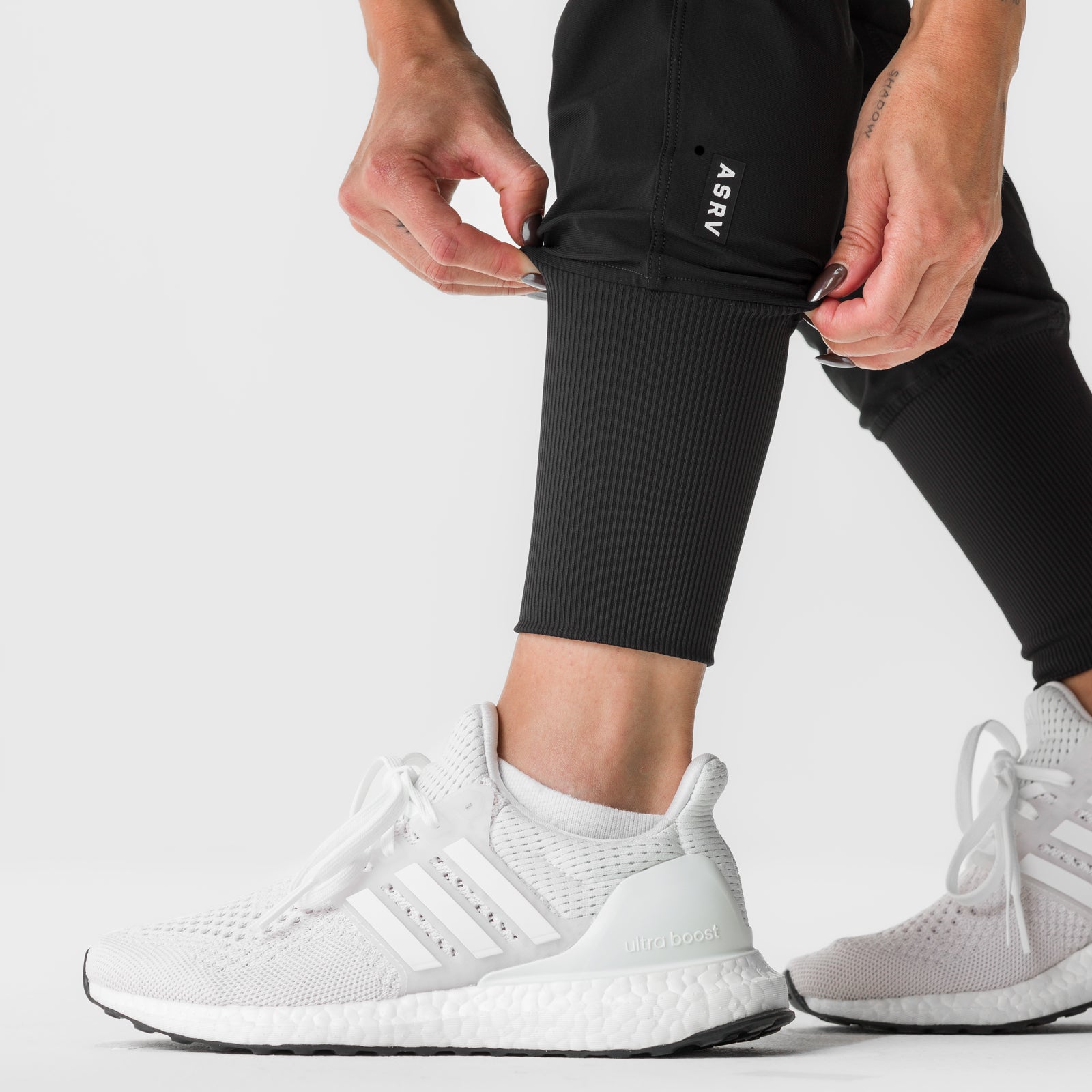 Black high-rib cargo jogger worn with white sneakers, lower body detail shot