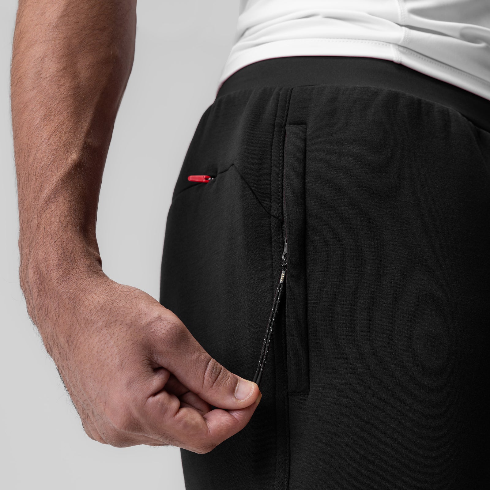 Black Dri-Core Training Jogger worn by model, side view showing zippered pocket detail