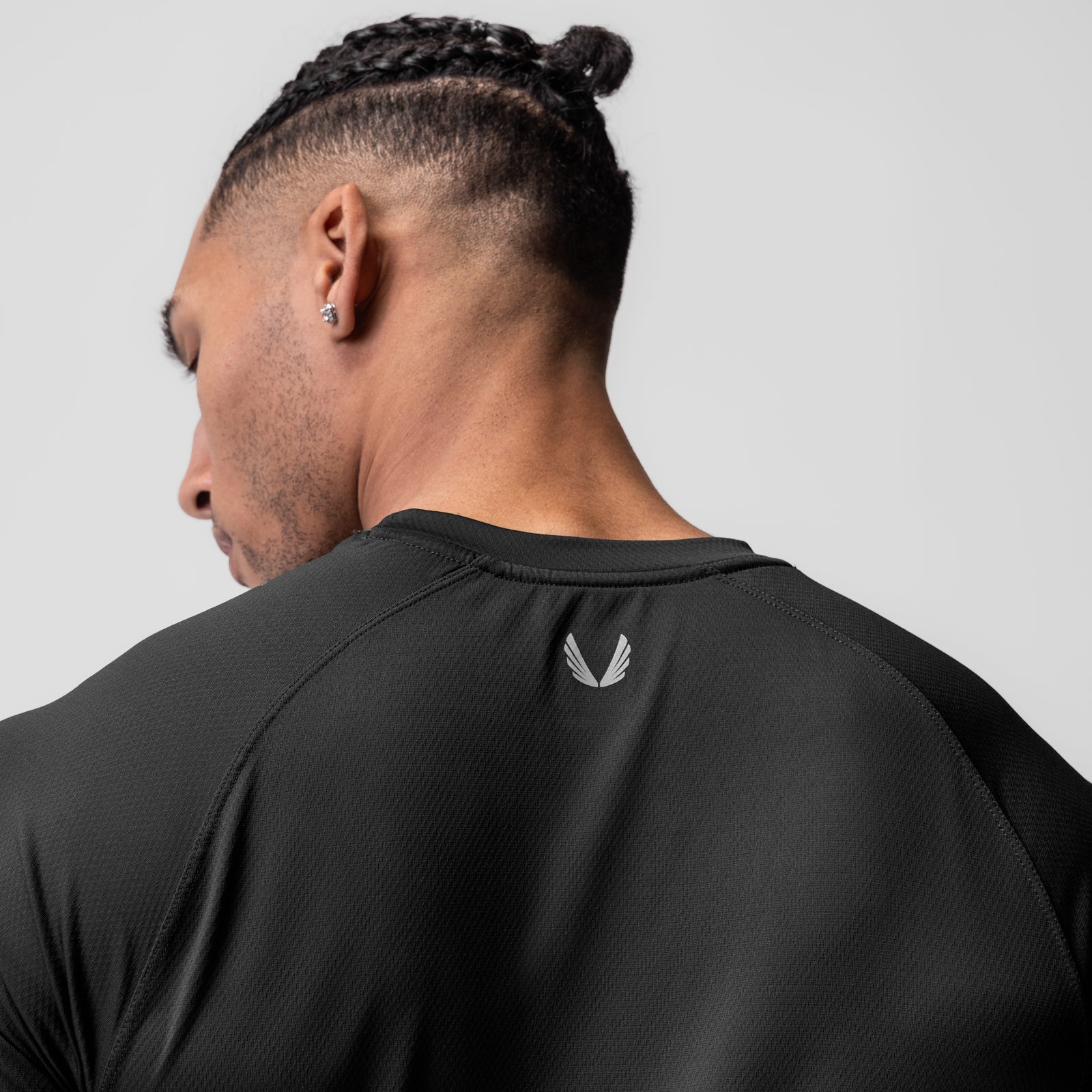 AeroSilver Established Tee in black worn by model, back view showing logo