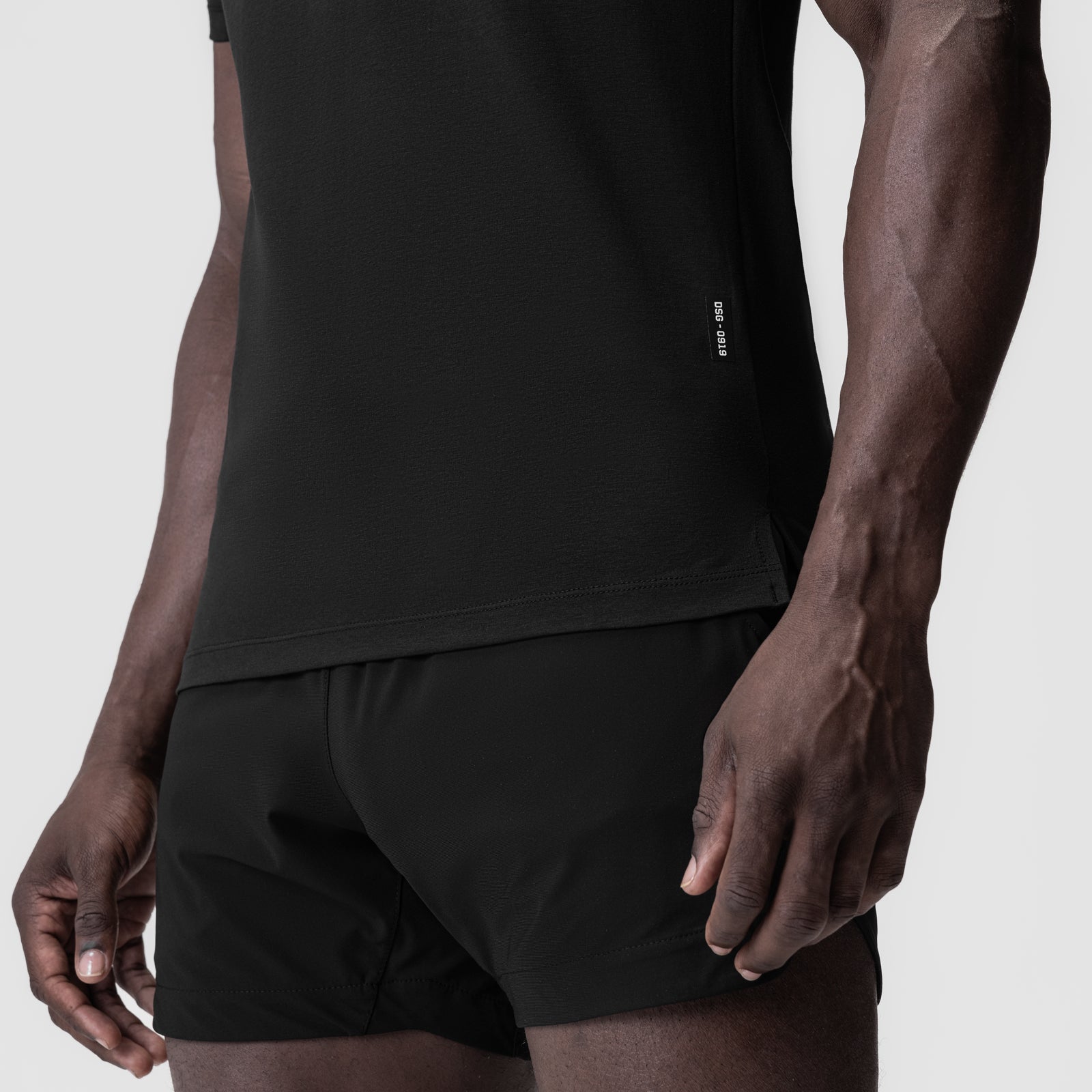 Black Supima® Fitted Tee worn with black shorts, side view on model