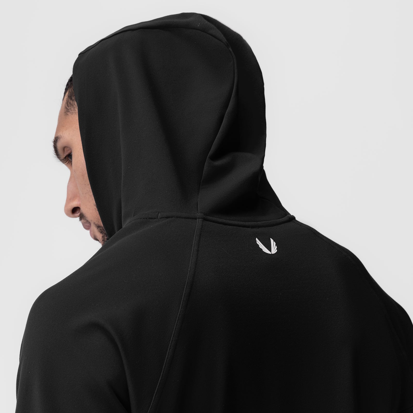 Black performance fleece zip hoodie worn by model, side profile view