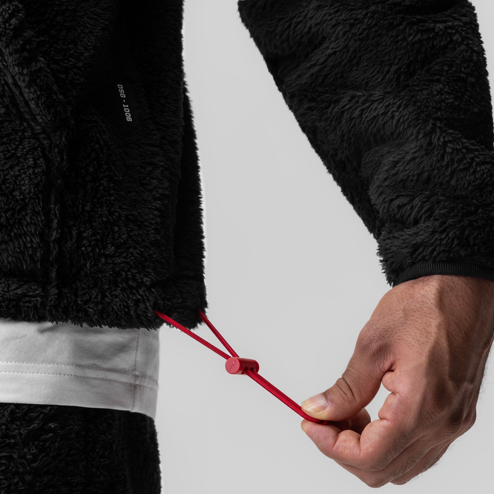 Sherpa Recovery 1/2 Zip in black, model holding red drawstring detail