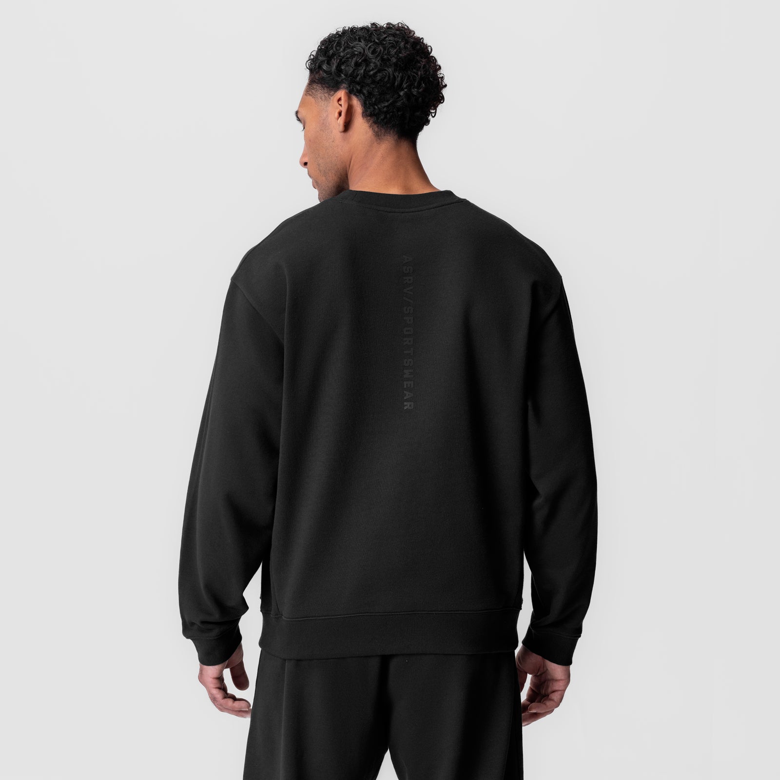 Black herringbone terry crewneck worn by model, back view