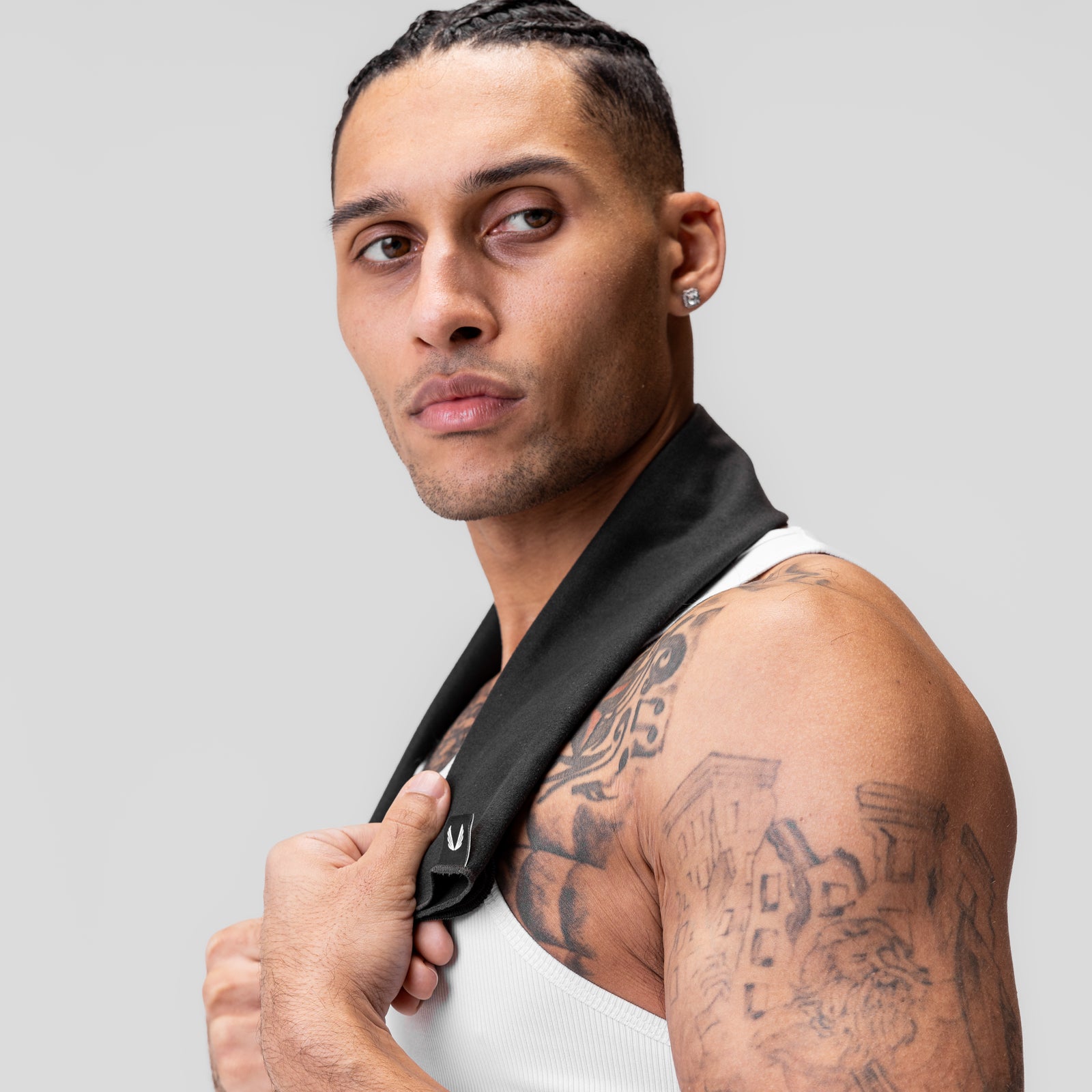 Black microfiber antibacterial gym towel draped over model's shoulder, product view
