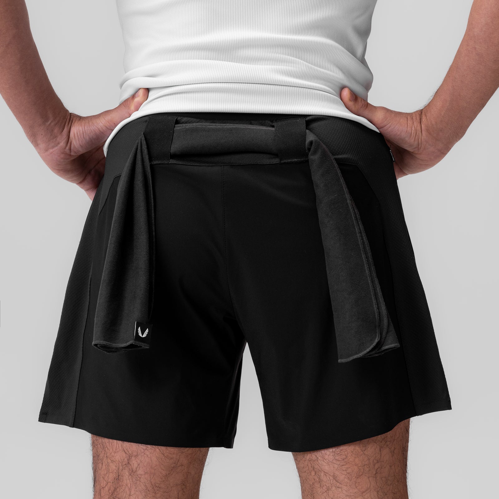 Black microfiber gym shorts on model, back view with hands on hips