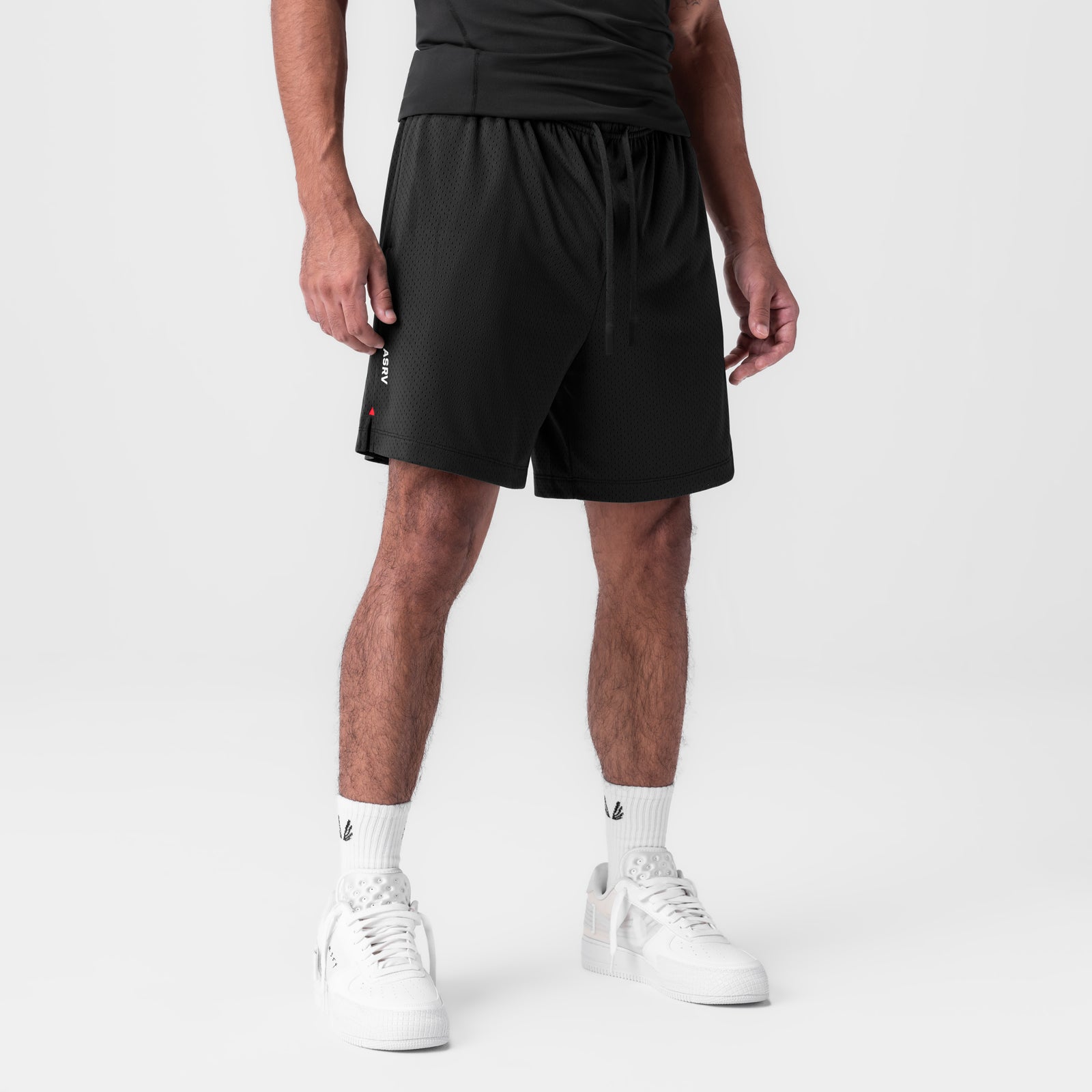 Reversible 2-in-1 shorts in black worn by male model with white sneakers and socks