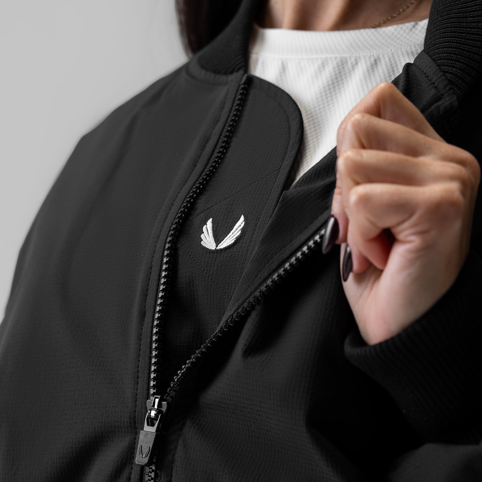 Women's sherpa-lined insulated bomber jacket in black, worn by model showing front zipper detail