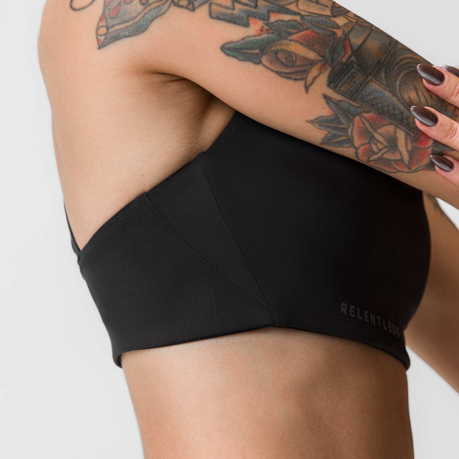 Black Lycra® Hybrid Sports Bra worn by tattooed model, front view