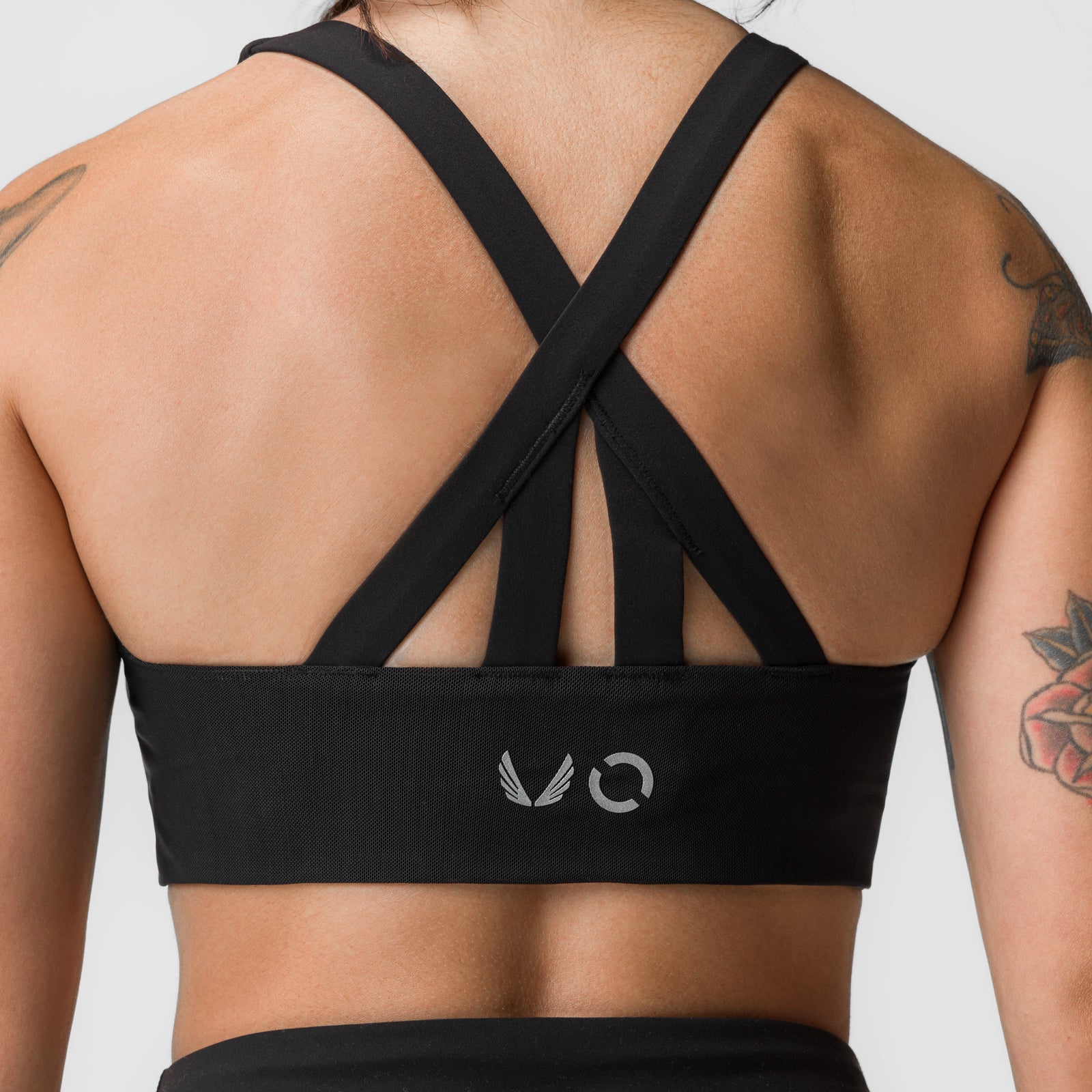 Black Lycra® hybrid sports bra with criss-cross straps, worn by model showing back view