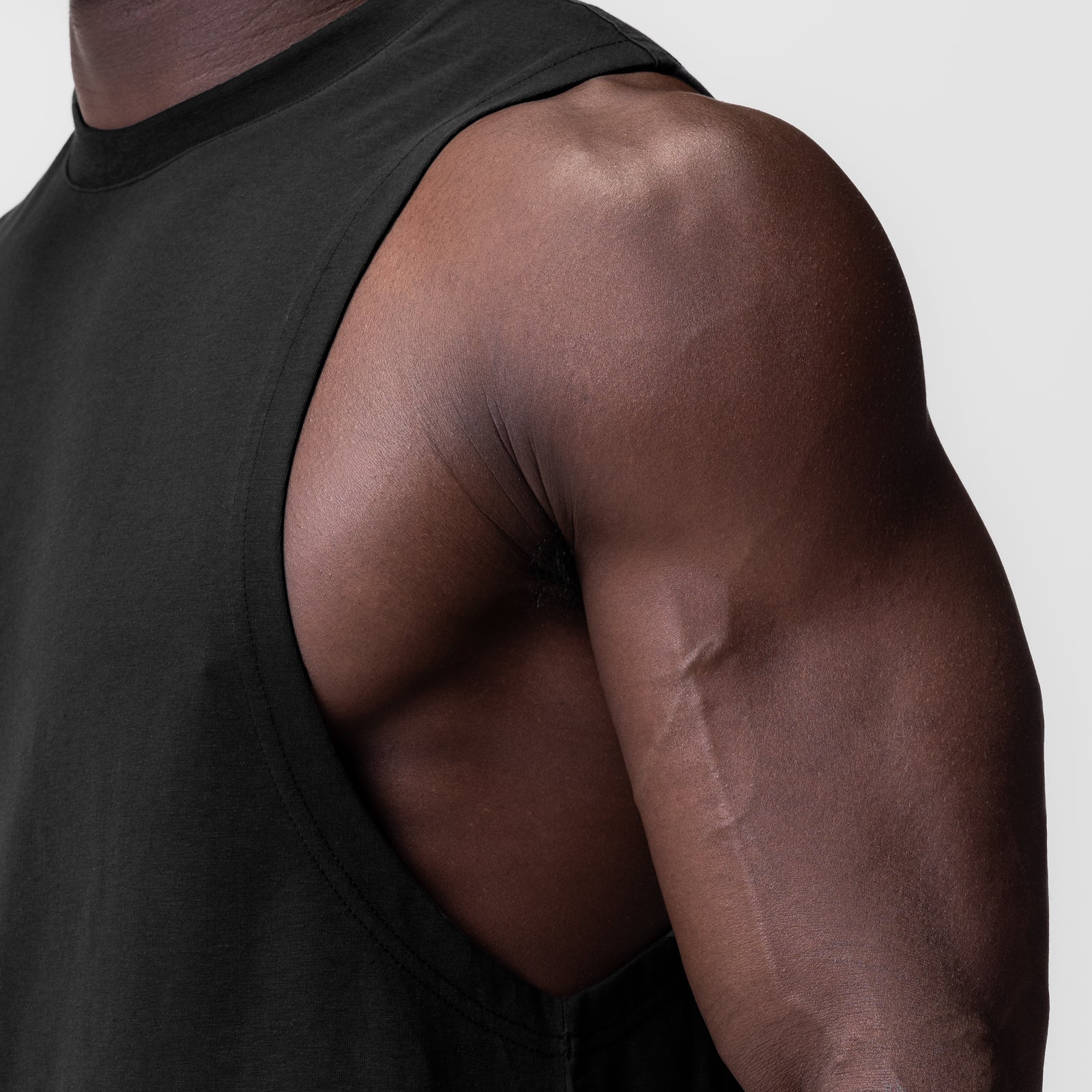 Black Supima® Muscle Tank on model, side view showcasing shoulder and arm fit