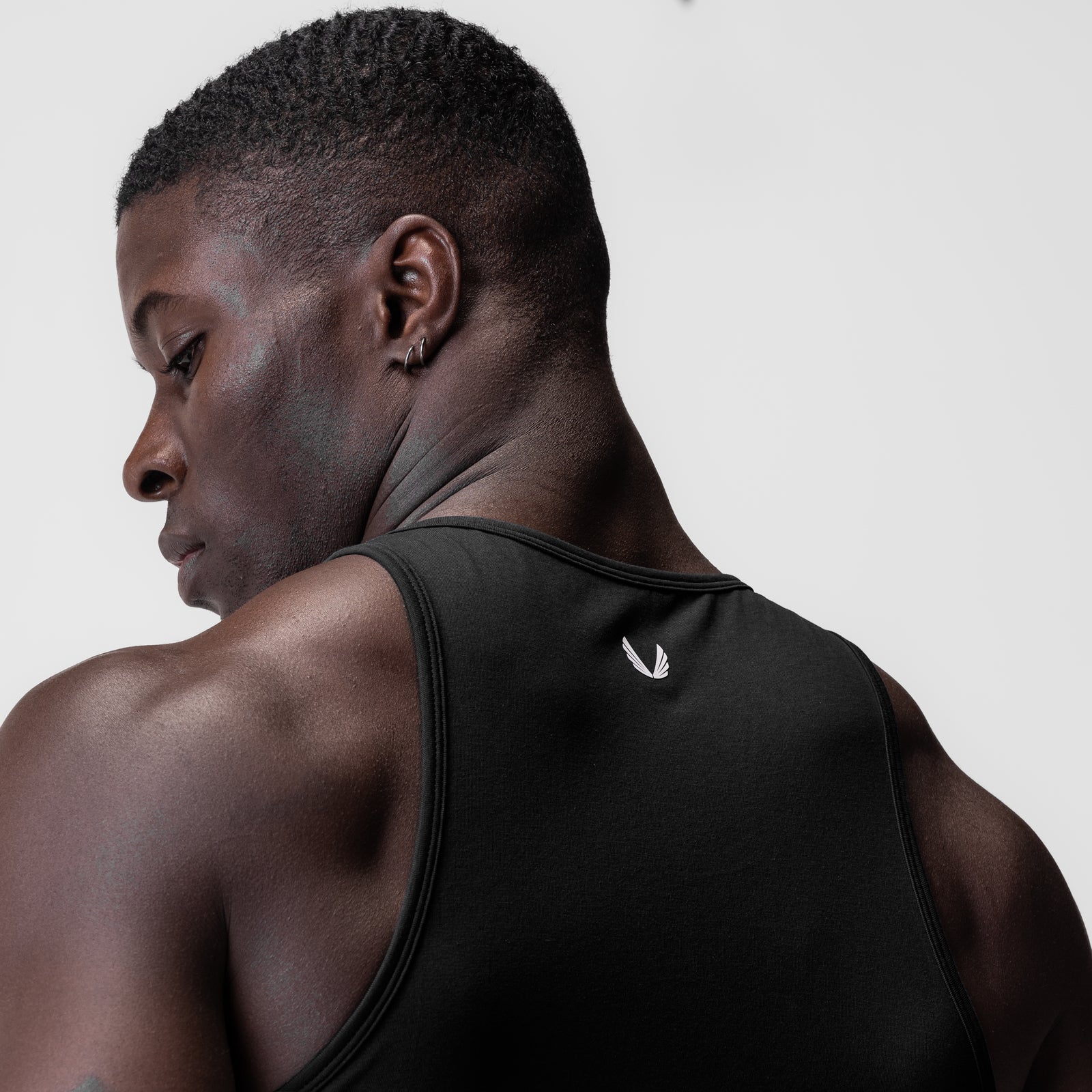 Supima Essential Slim Tank in black, worn by model in profile view