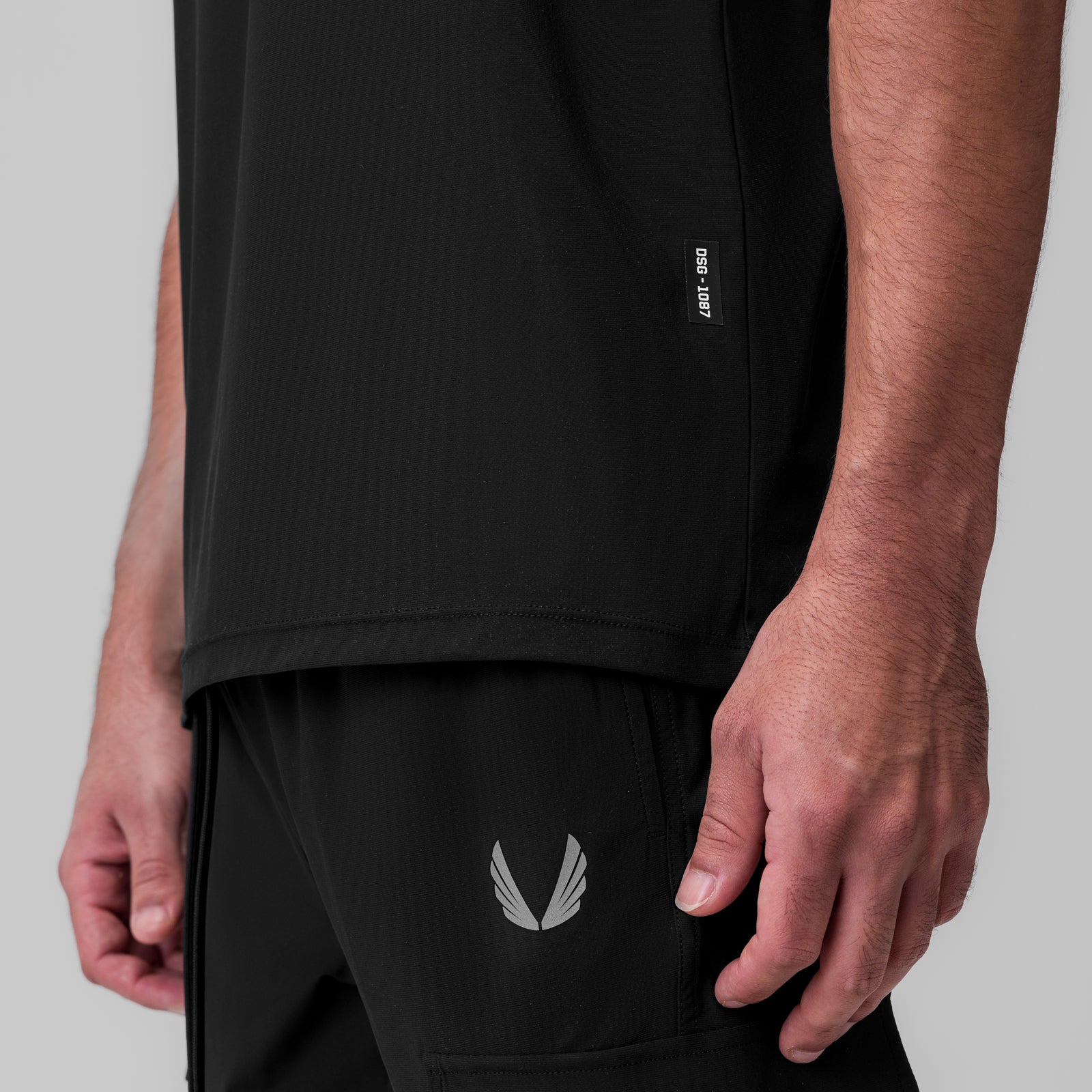 Tetra-Lite® Ice Zip Tee in black worn by model, side view showing fit and winged logo