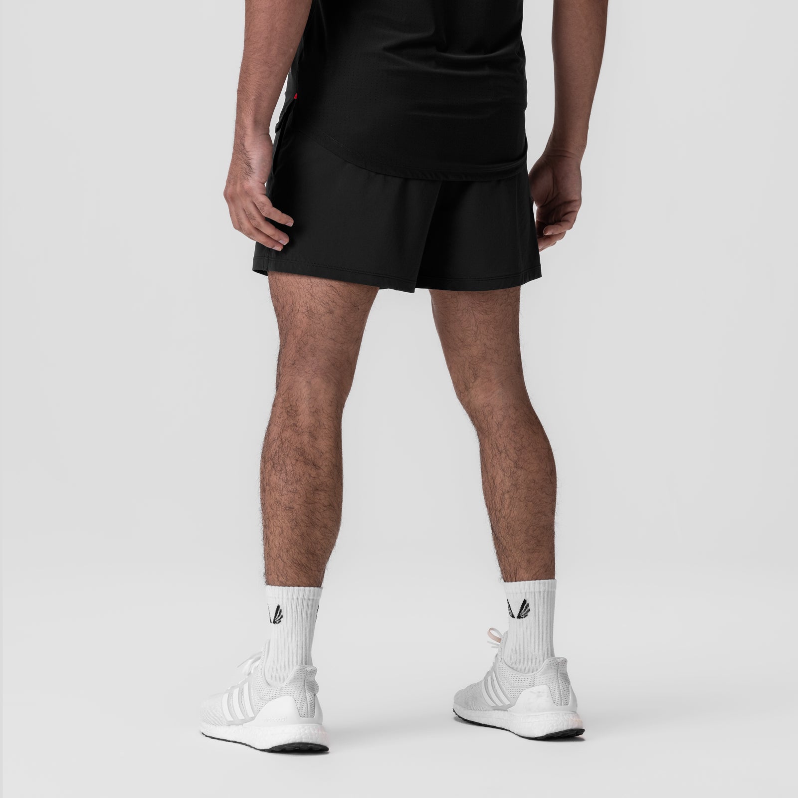 Black Aerotex™ 5" Training Short worn by model with white socks, rear view