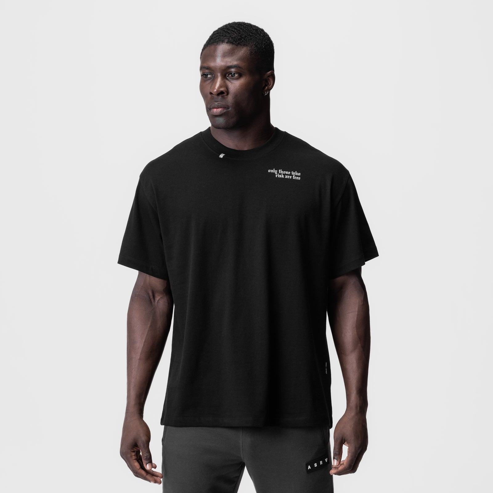 Black Tech Essential Relaxed Tee with 'Brush Wings' text, worn by model, front view
