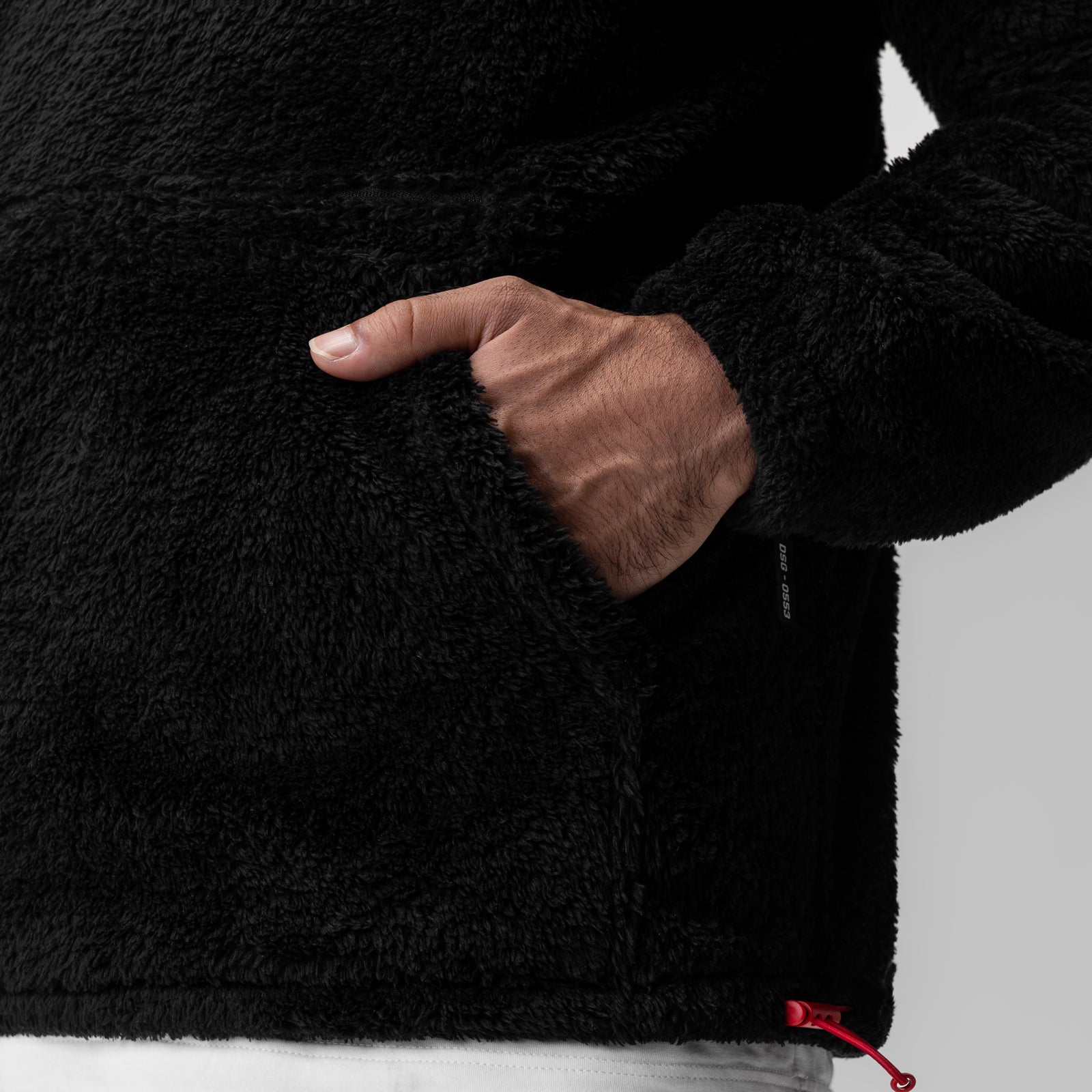 Black Sherpa Recovery Hoodie with white wing detail, worn by model with hand in pocket