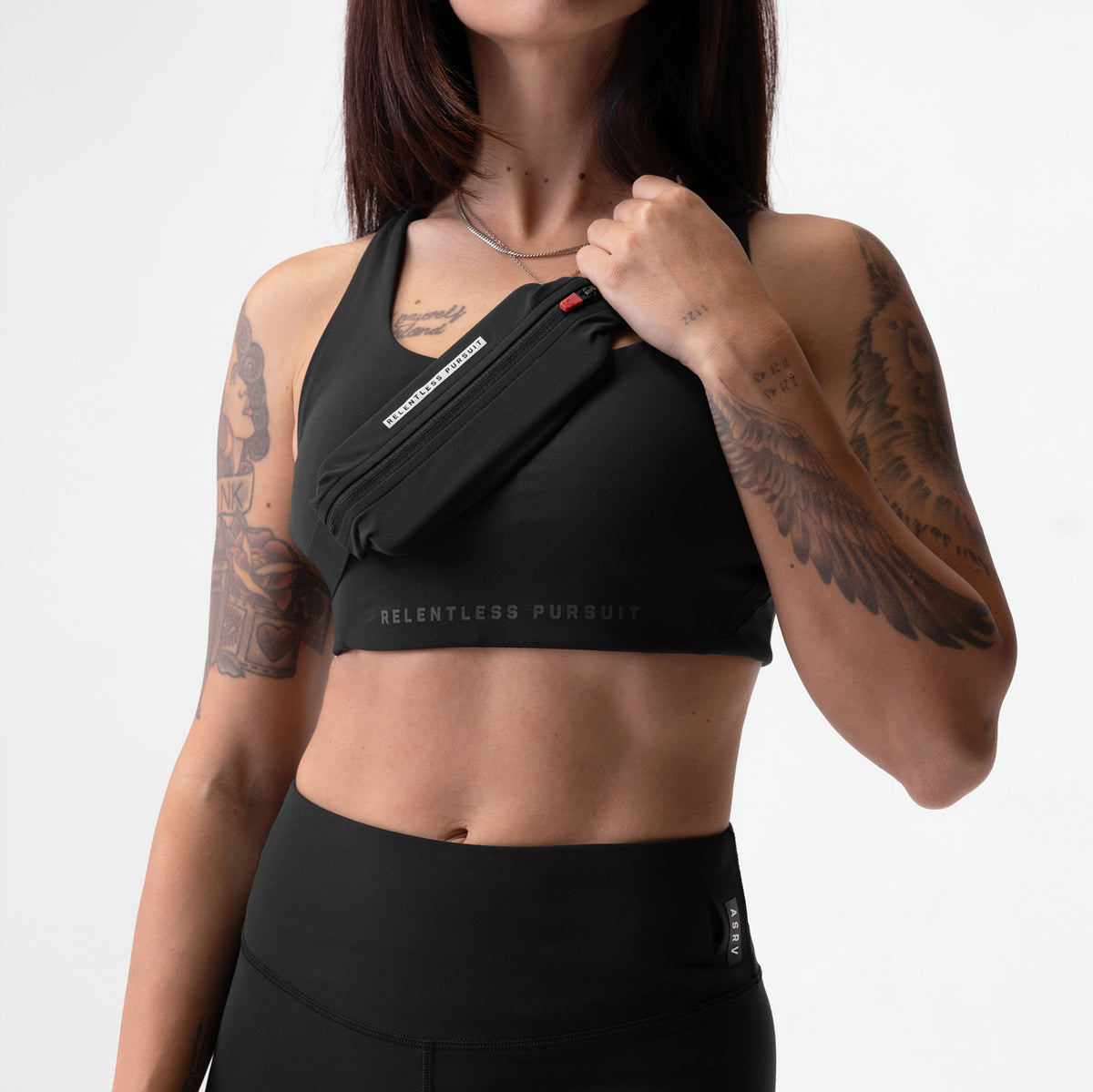 ASRV x Equinox Lycra® 3-In-1 Legging in black, worn with matching sports bra and shoulder bag