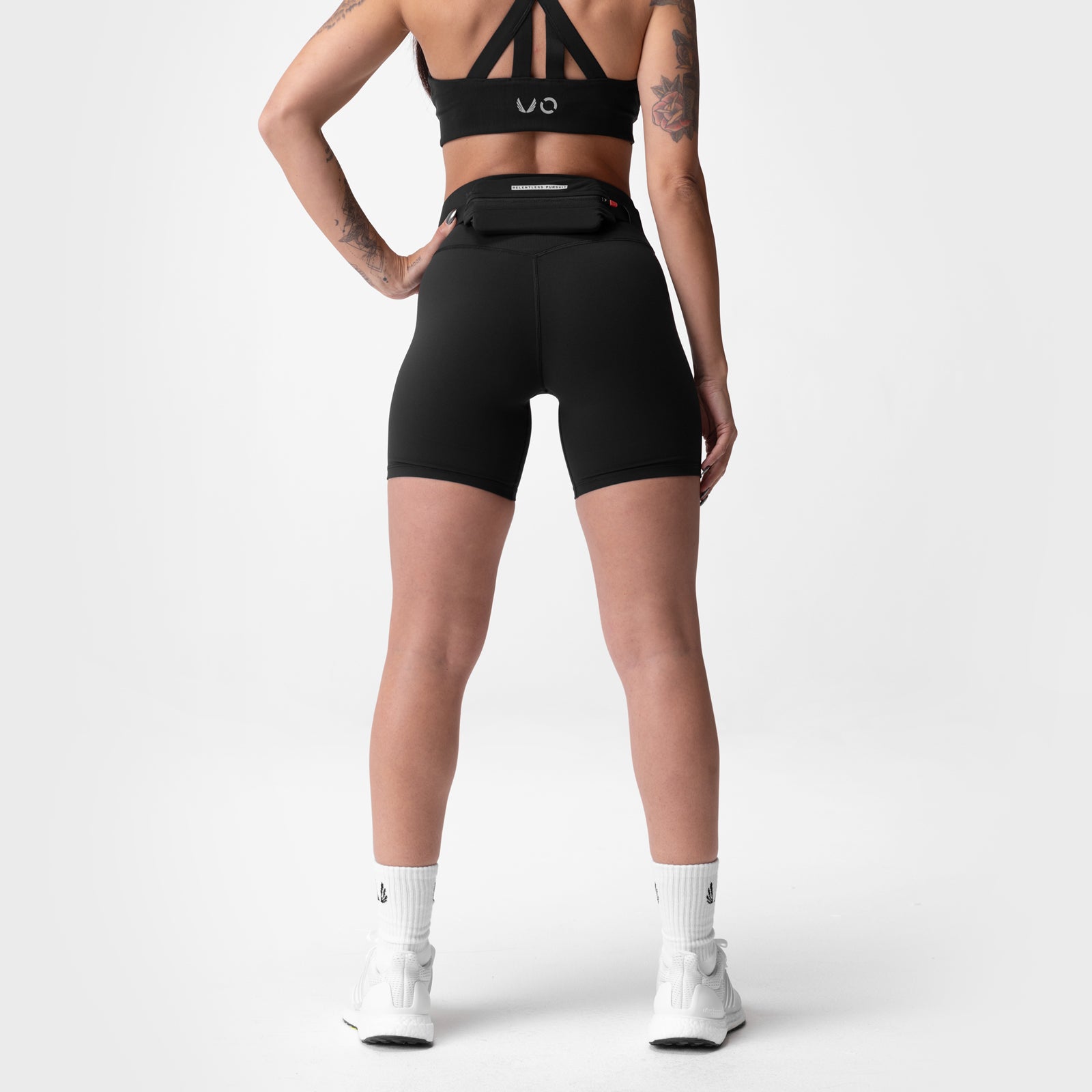 Black Lycra biker shorts worn by model, rear view, paired with white socks