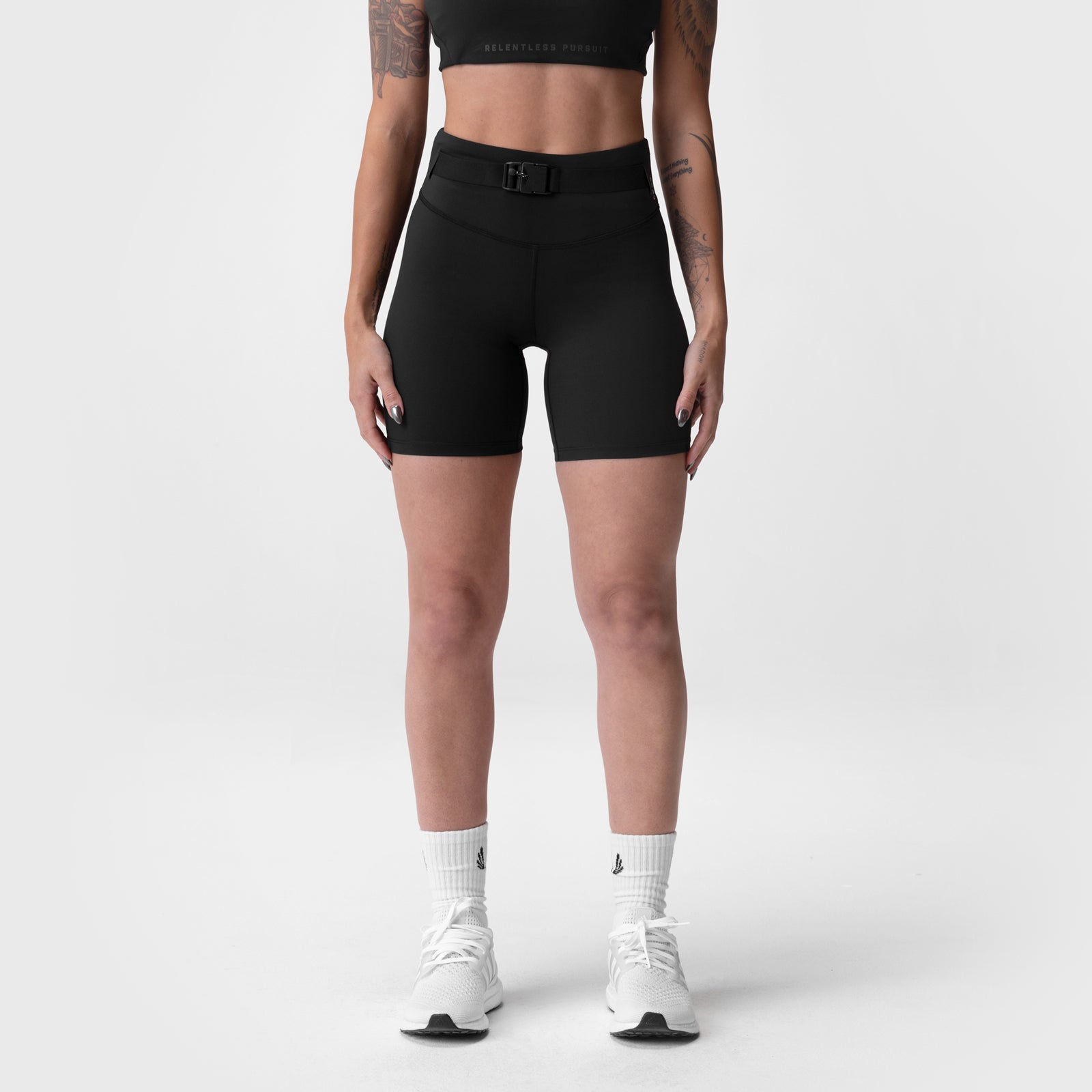 Black LYCRA® 3-in-1 biker shorts worn with white socks and sneakers, front view