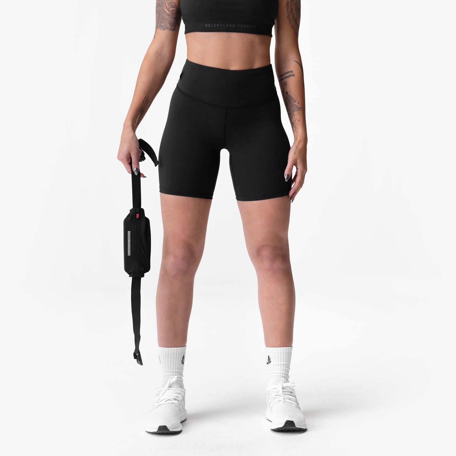 Black Lycra 3-in-1 biker shorts on model holding water bottle, front view