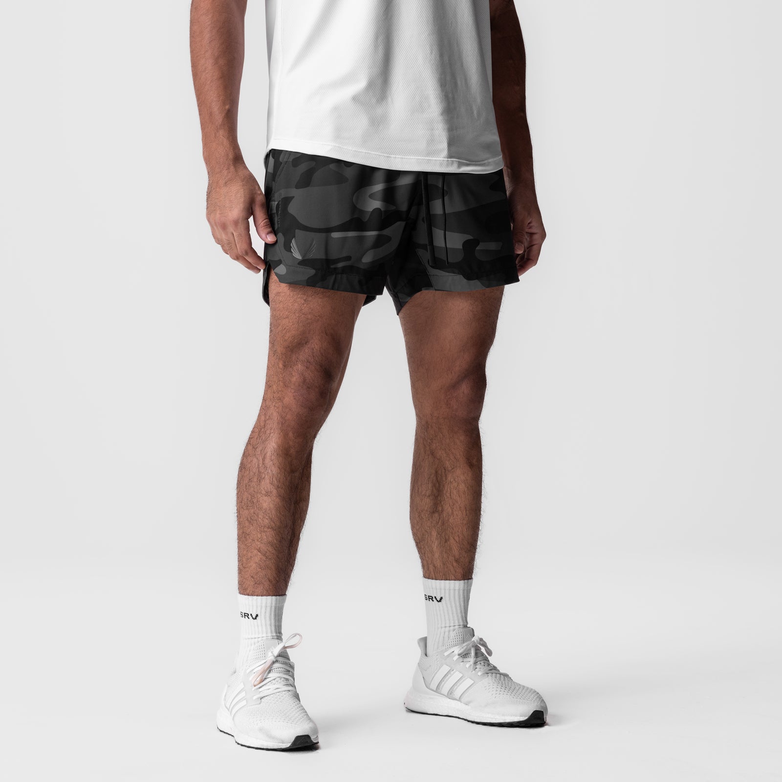Tetra-Lite 5" Linerless Short in black camo, worn by model with white socks and sneakers