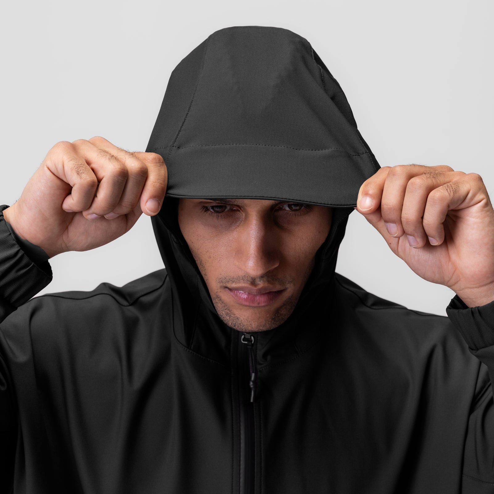 Weather-Ready Anorak Jacket in black, worn by model pulling hood down over face