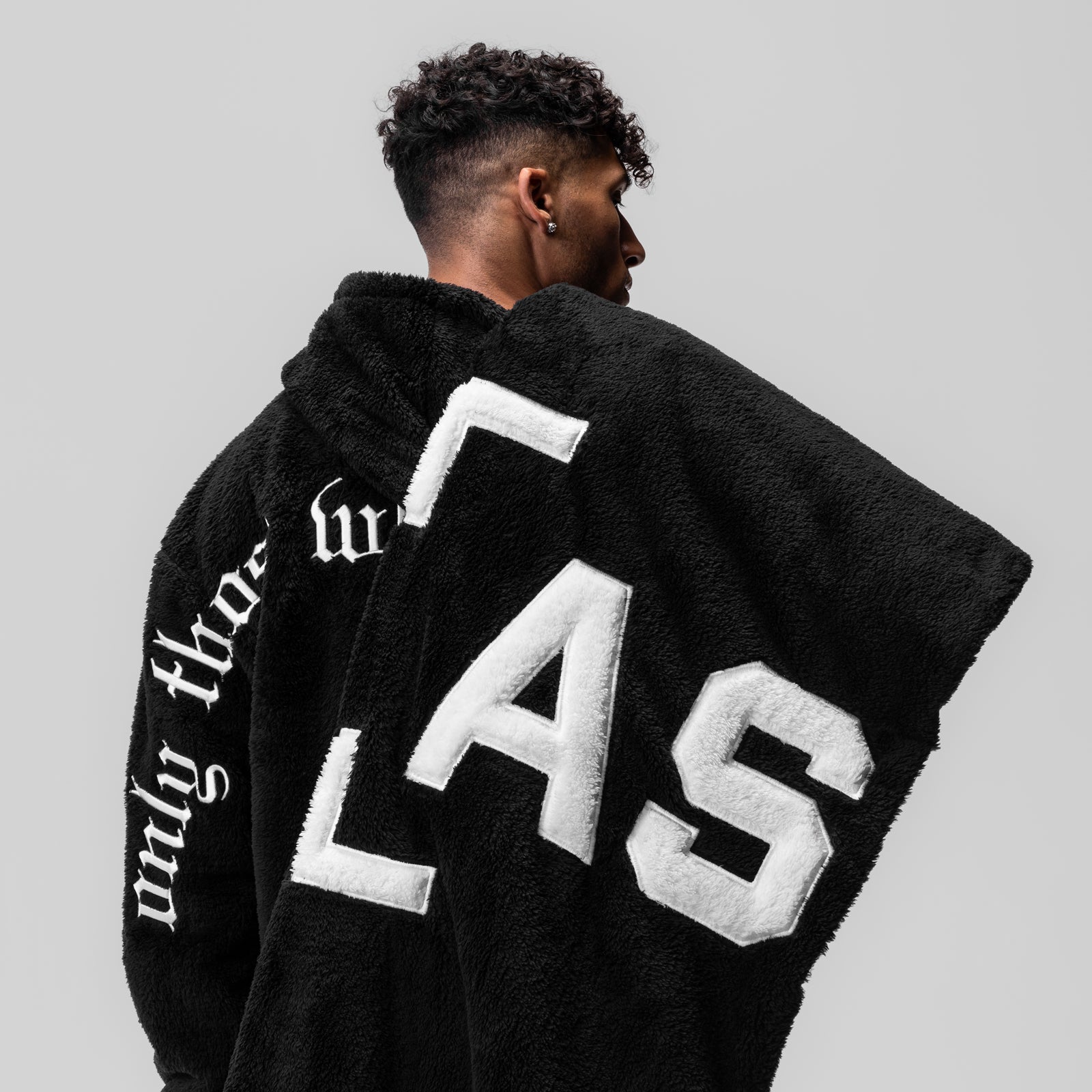 Black Sherpa Recovery Blanket with white FAB lettering, worn by model from behind