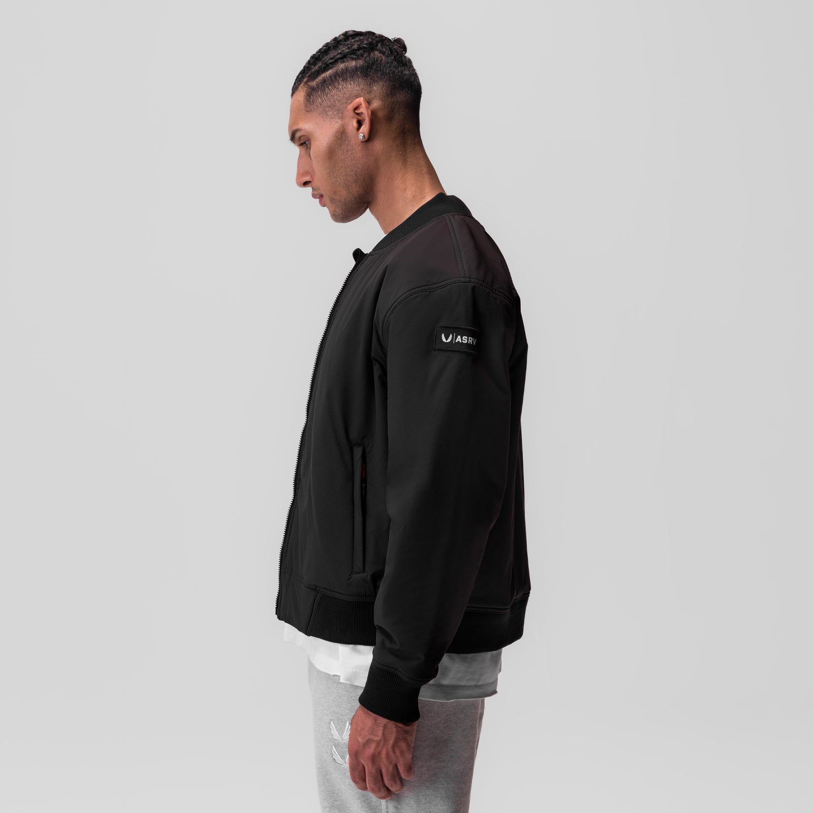 Black ripstop insulated bomber jacket worn by model in side profile view