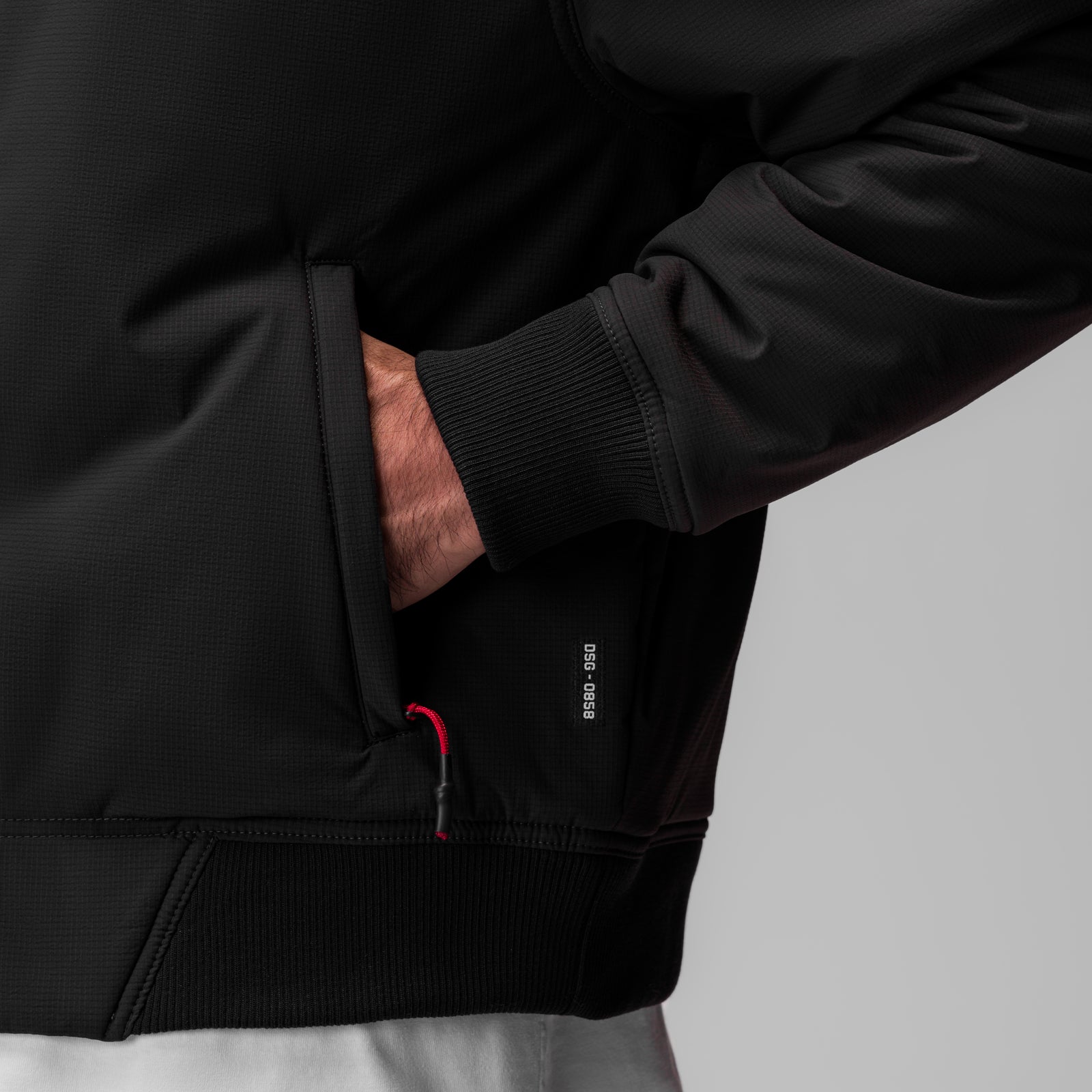 Black ripstop insulated bomber jacket worn by model, showing sleeve and torso detail