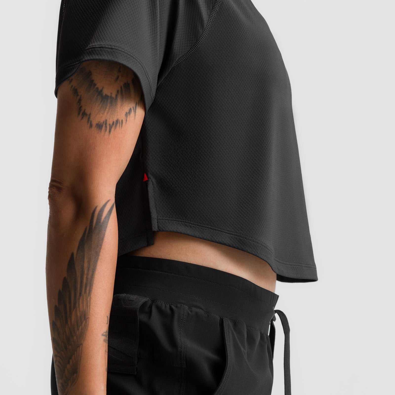 Black AeroSilver cropped training tee on model, side view showing fit and tattoos