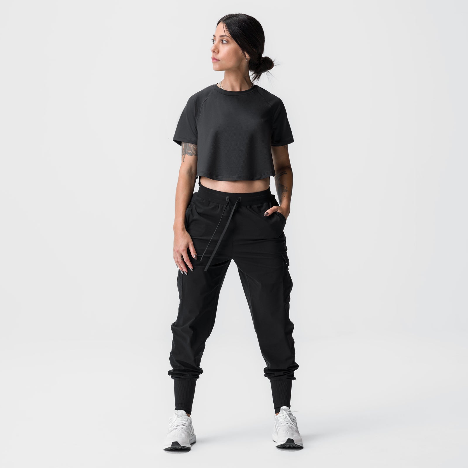 Black cropped training tee worn with black cargo joggers and white sneakers, front view