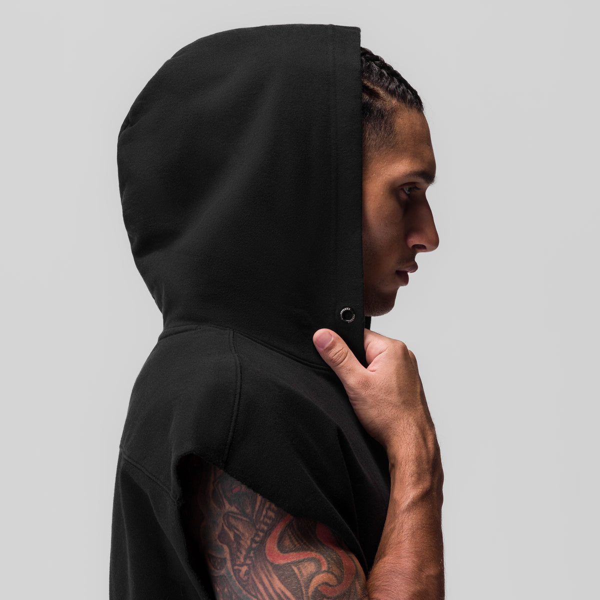 Black Tech Essential Raw Hem Cutoff Hoodie worn by model in profile, hood up