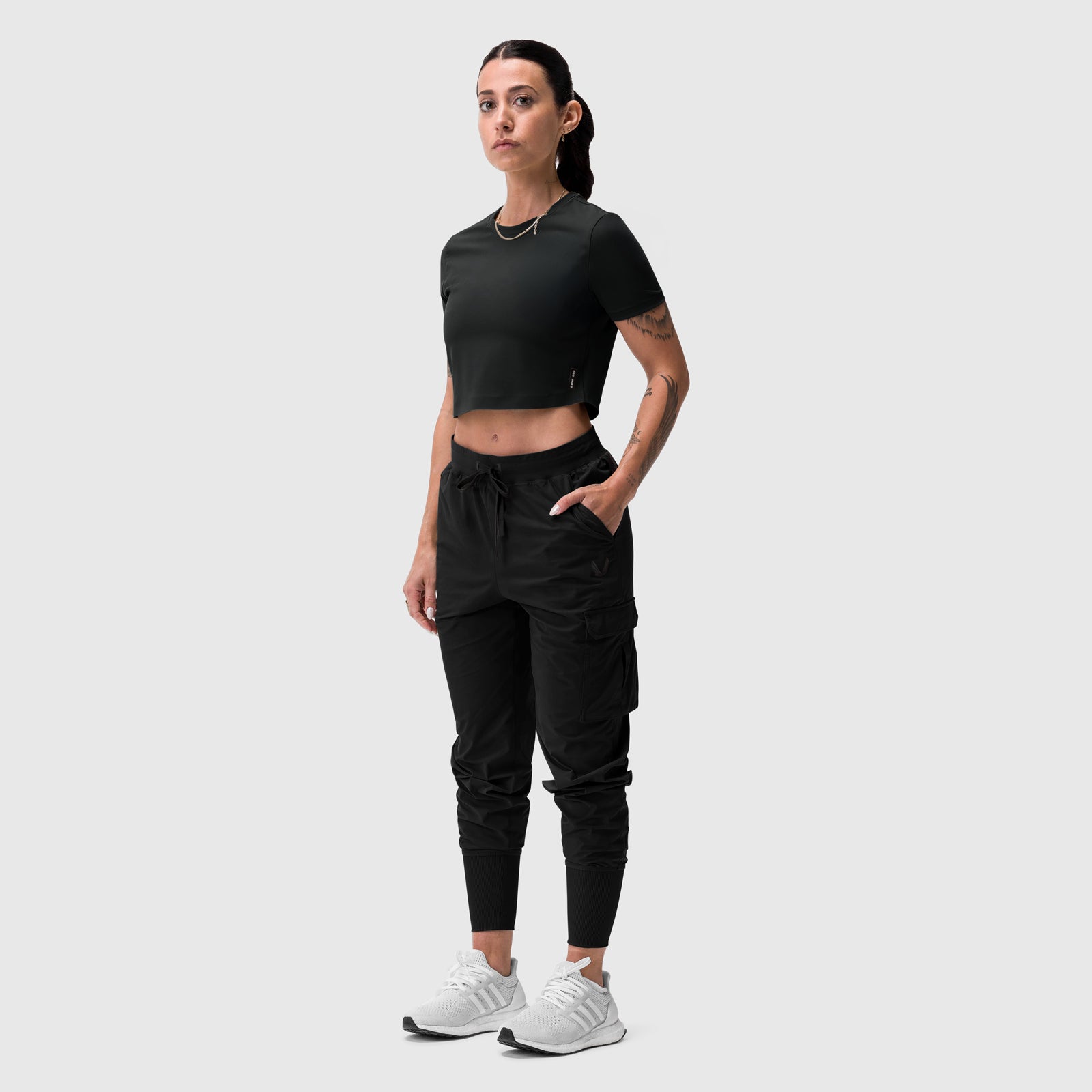 Black cropped tee worn with black cargo joggers and white sneakers, front view