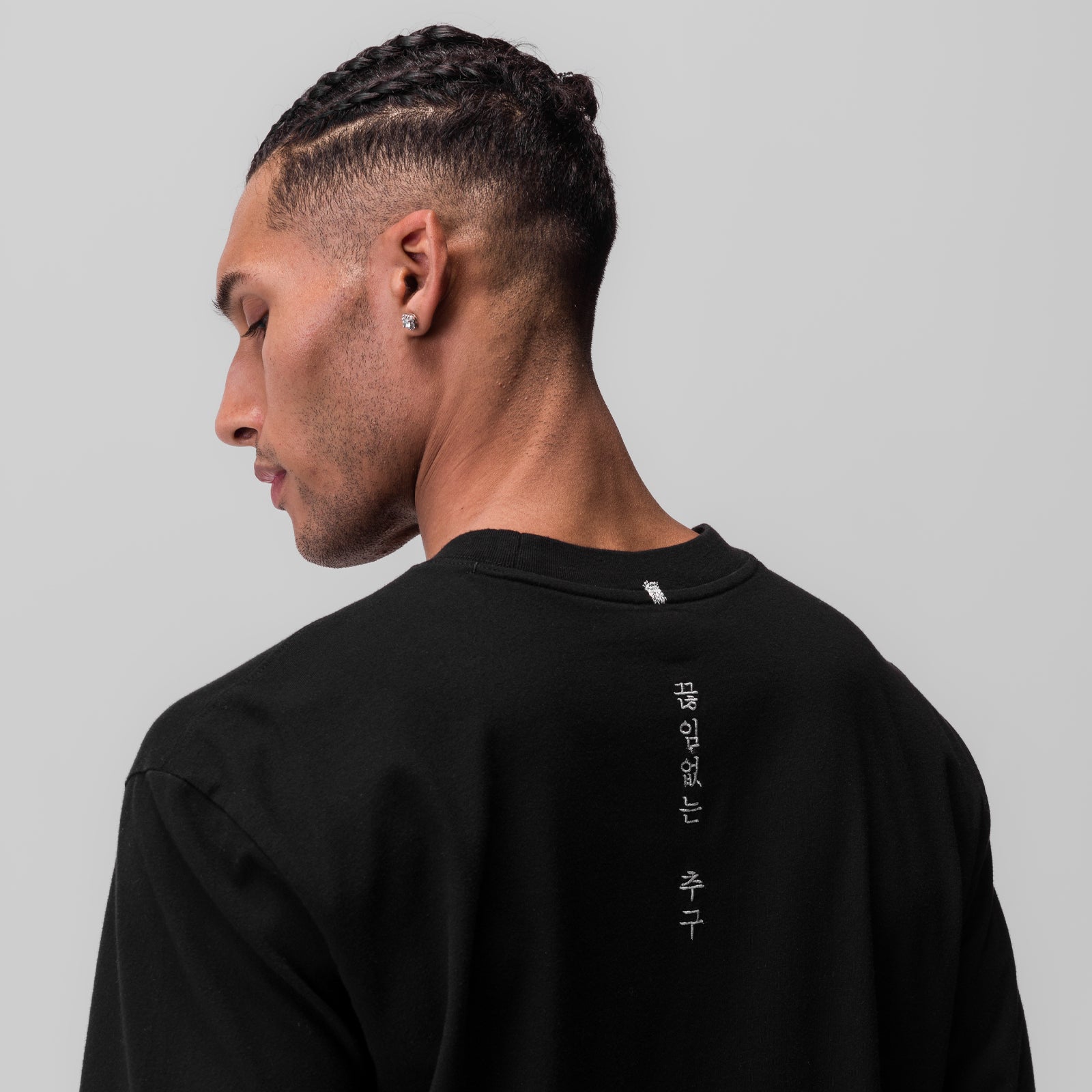 Black Tech Essential Relaxed Long Sleeve worn by model, back view showing vertical text detail