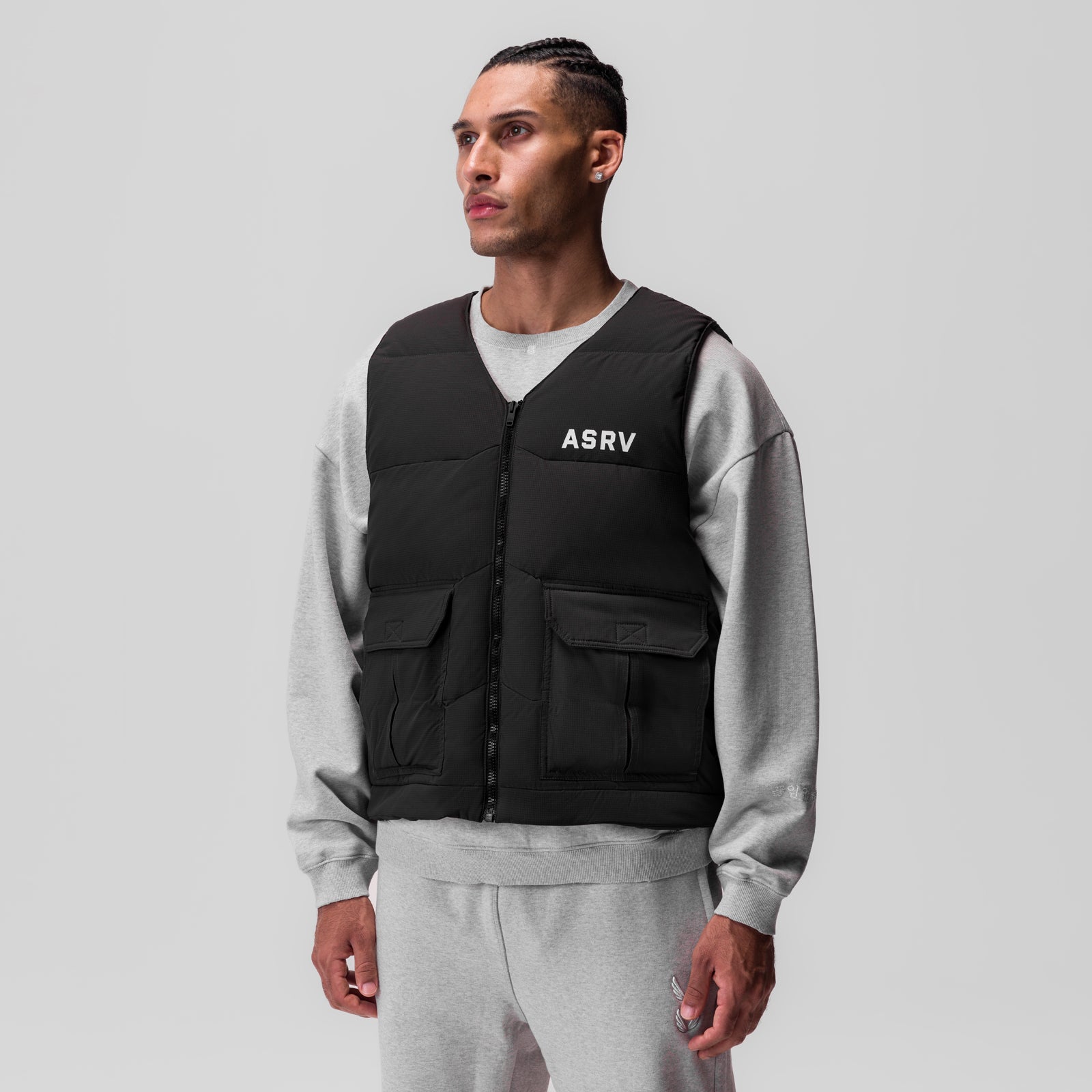 Black ripstop insulated puffer gilet worn over grey crewneck sweatshirt, front view