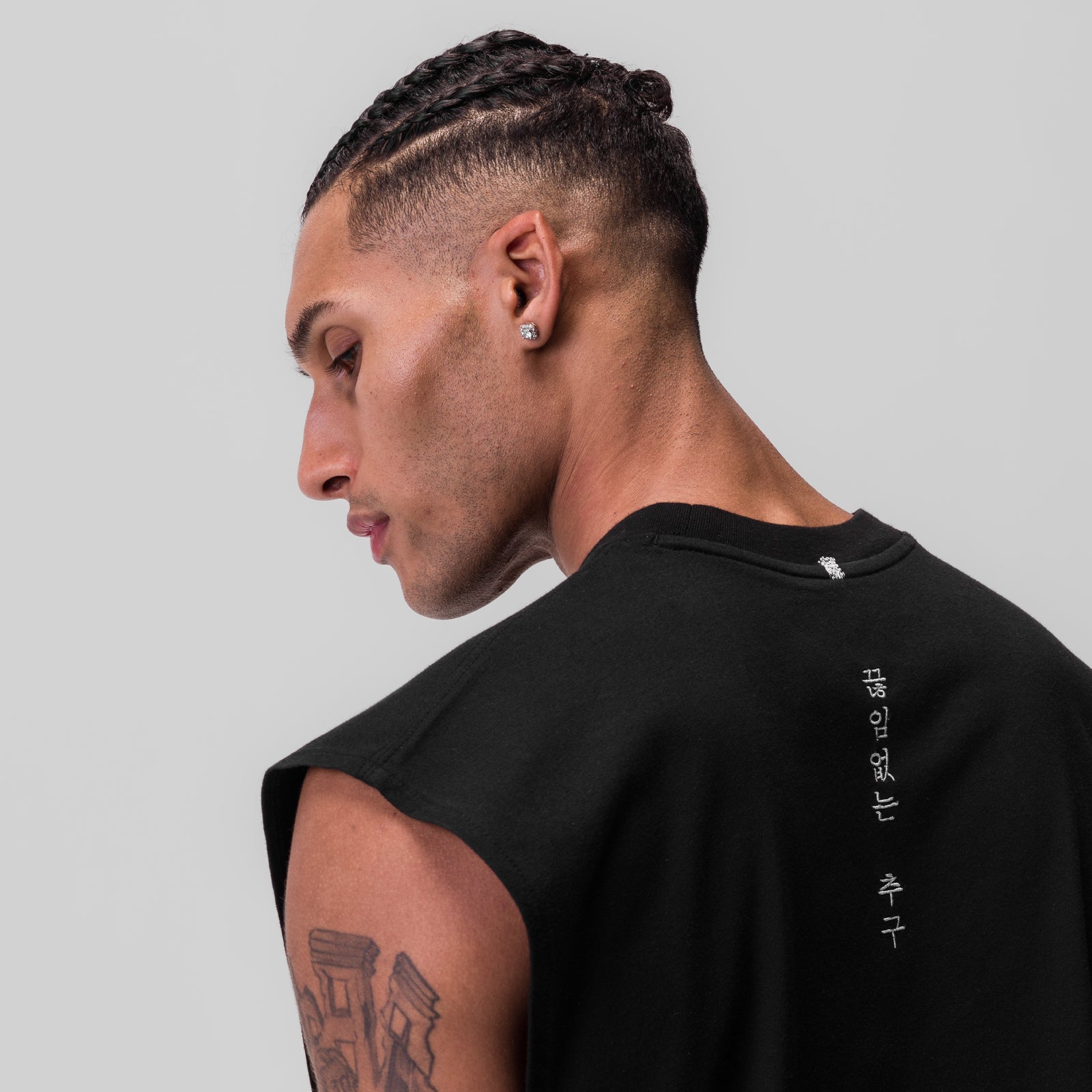 Black Tech Essential Rocker Cutoff worn by model in profile view, showing back design