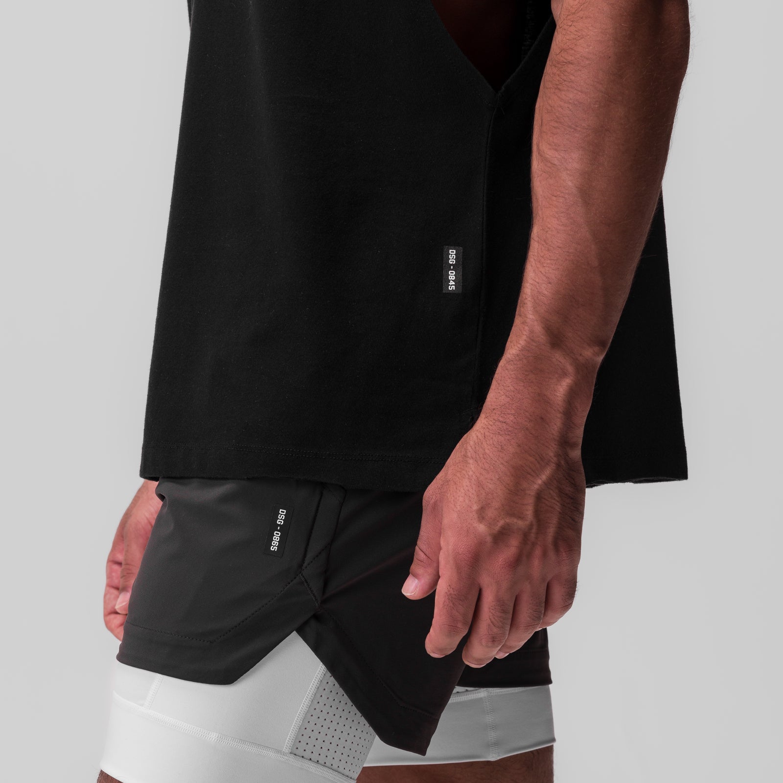 Tech Essential Rocker Cutoff shorts in black, worn by model showing side view