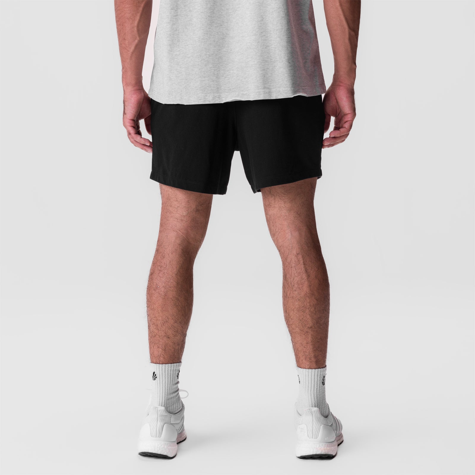 Tech Essential Sweat Short in black, back view on model wearing grey tank and white socks