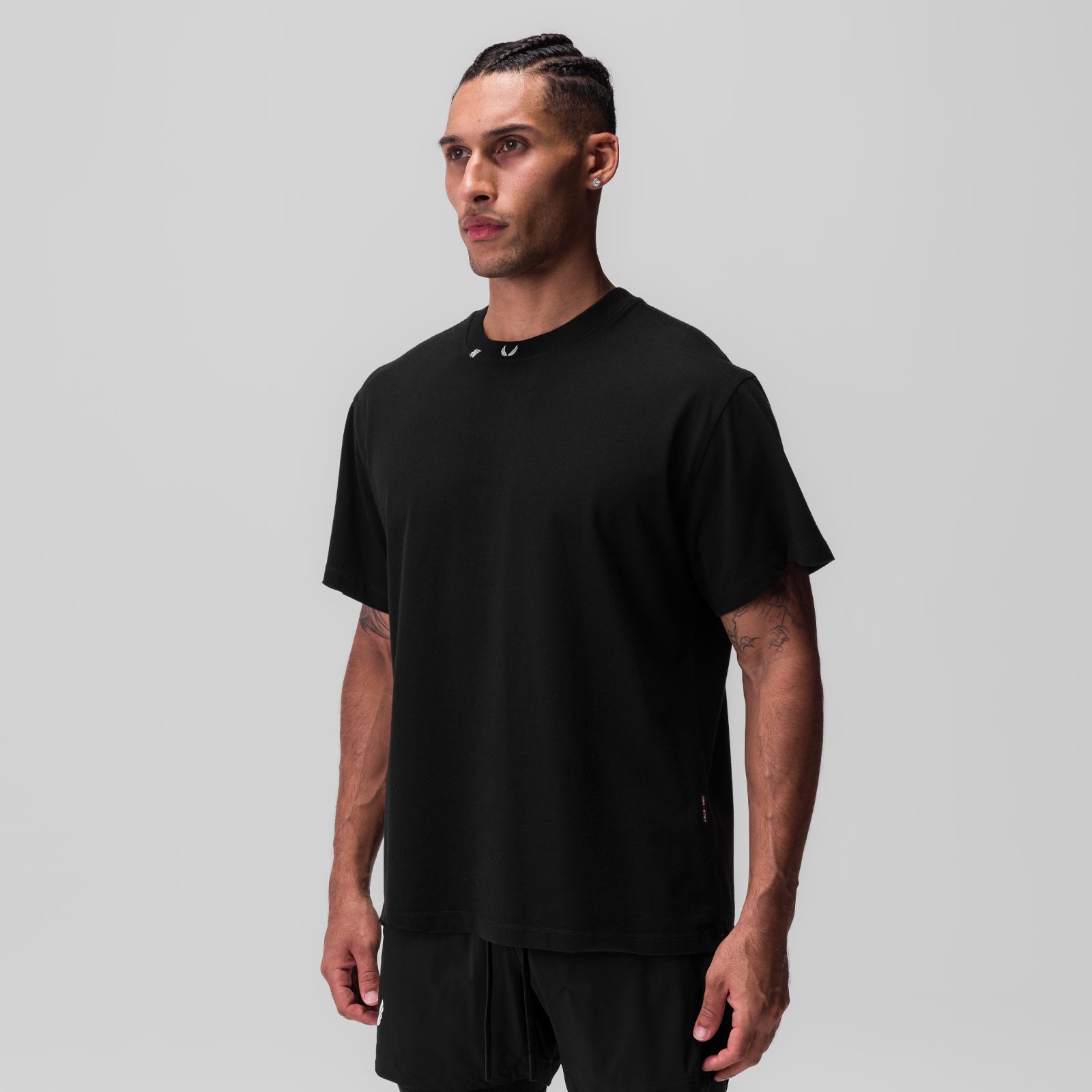 Tech Essential Relaxed Tee in black, modeled by man in three-quarter view against gray background