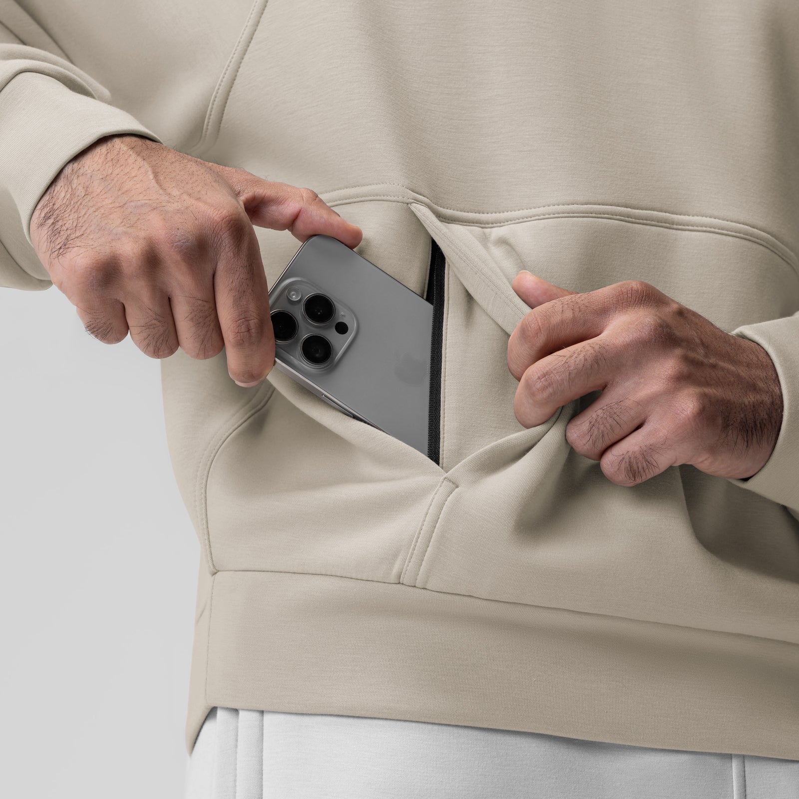 Dri-Core Oversized Crewneck in Chai being worn, model holding phone in kangaroo pocket