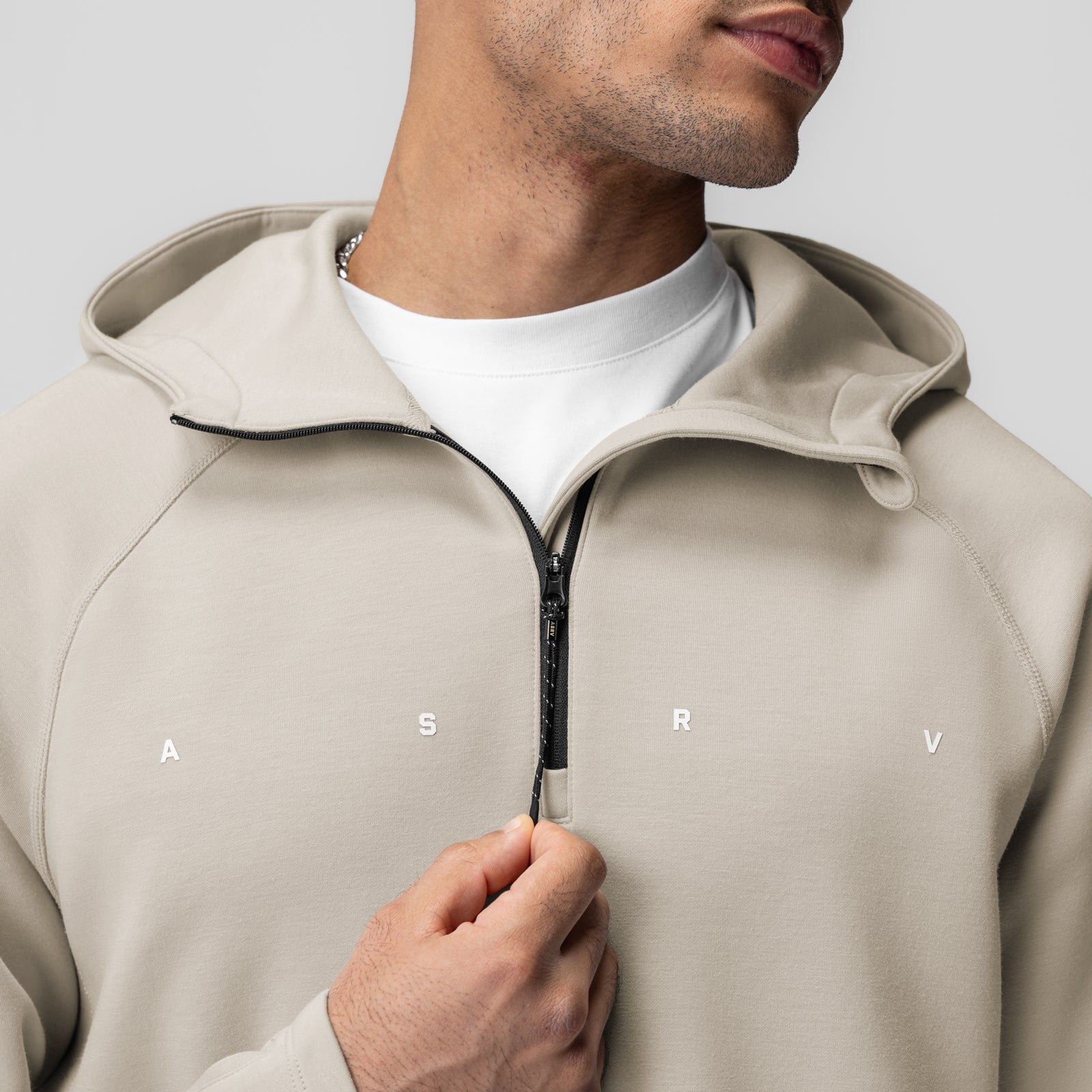 Dri-Core™ Zip Hoodie in Chai worn by model, front view with hand on zipper