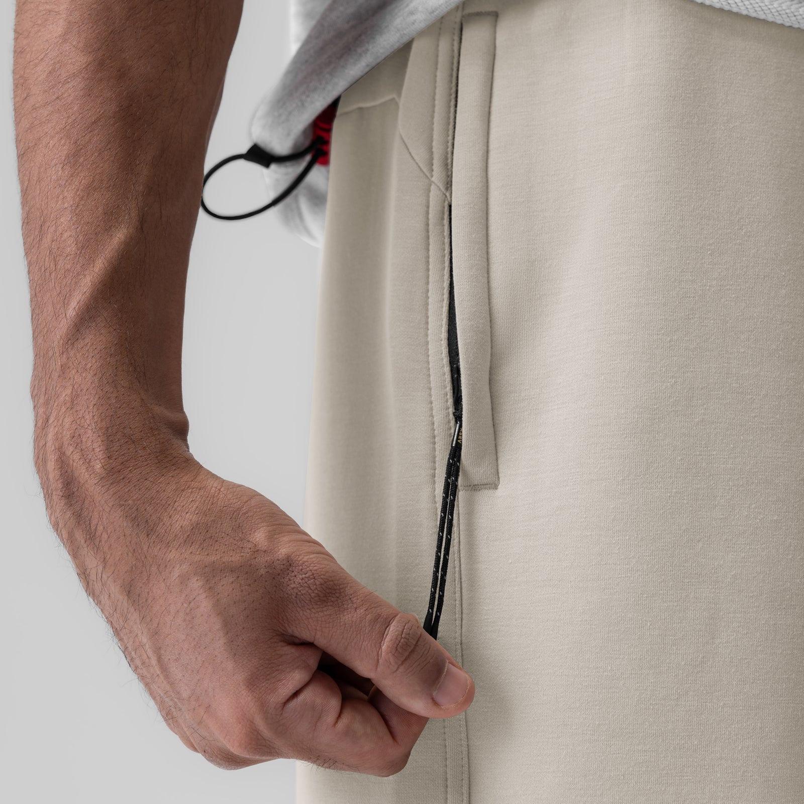 Dri-Core Training Short in Chai being held by model, showing drawstring detail
