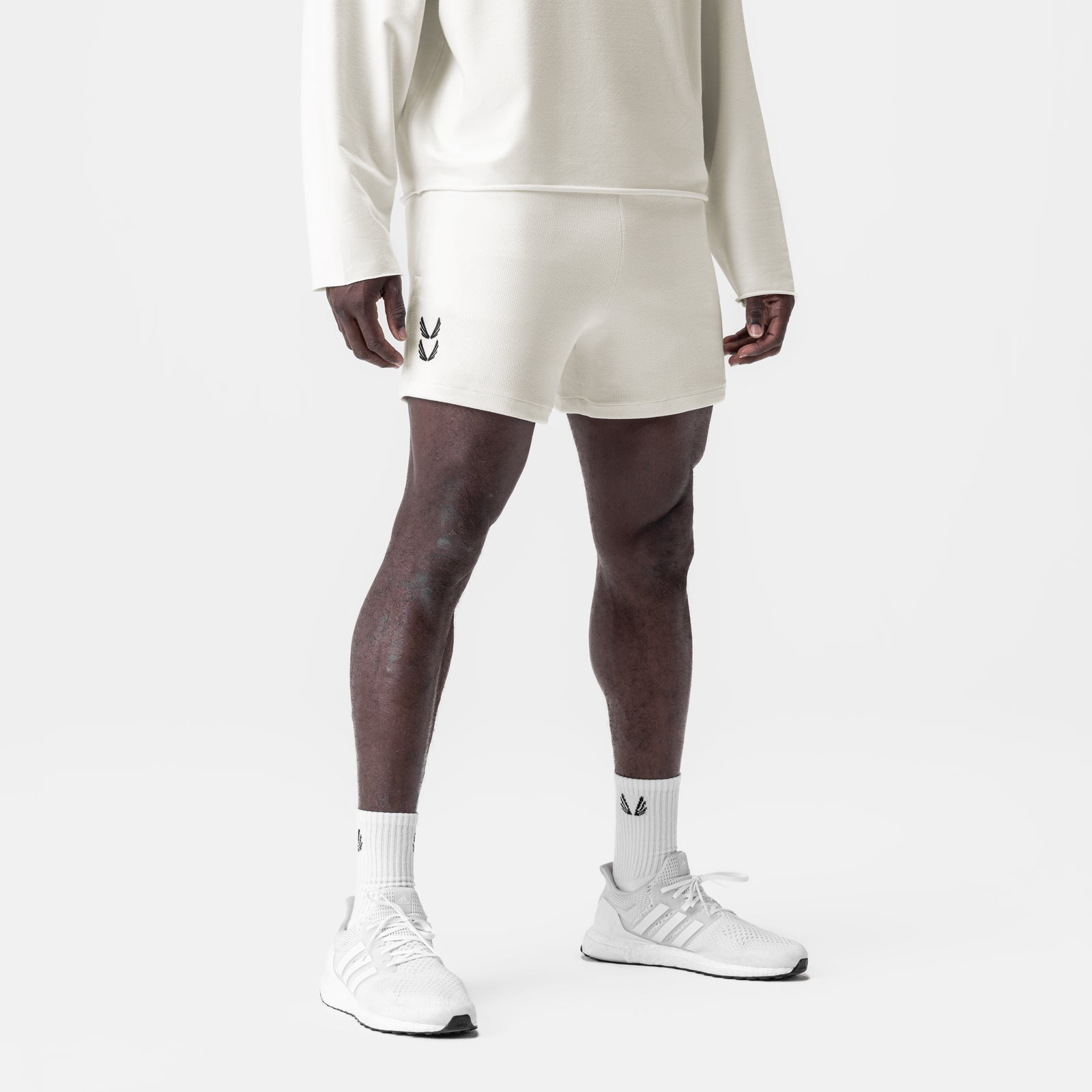 Cream waffle knit sweat shorts worn with white crew socks and sneakers, front view