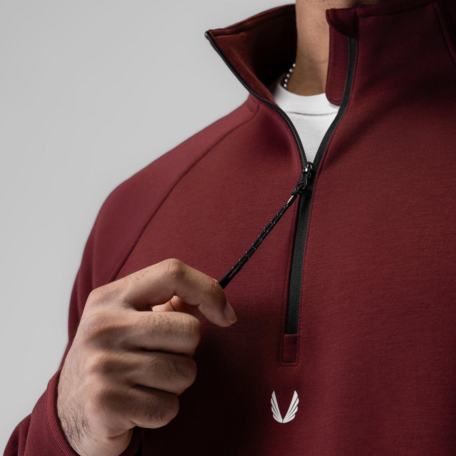 Dri-Core™ Quarter Zip in crimson, worn by model holding zipper pull