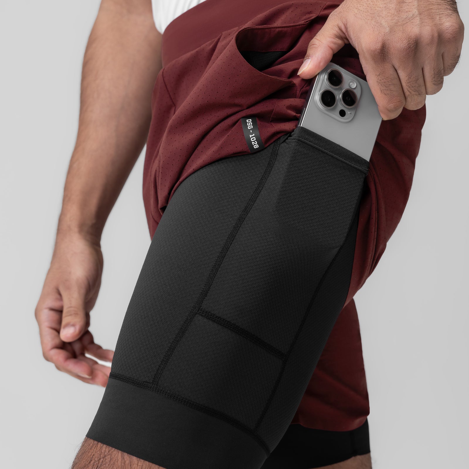 Aerotex™ Bonded 7" Liner Short in Crimson, model holding phone in side pocket