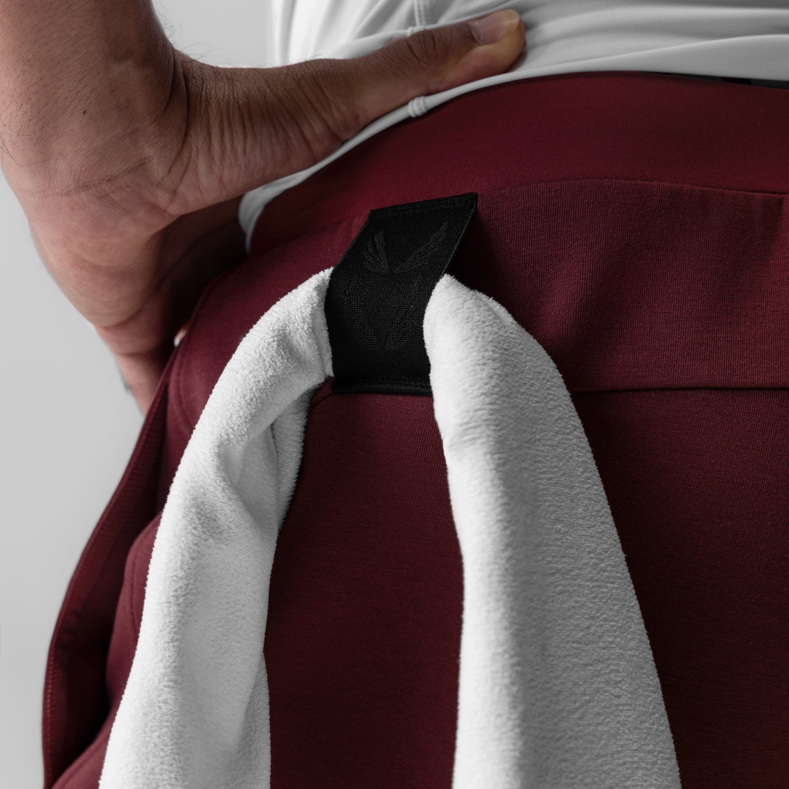 Dri-Core Training Jogger in Crimson being held by model, showing fabric detail and design