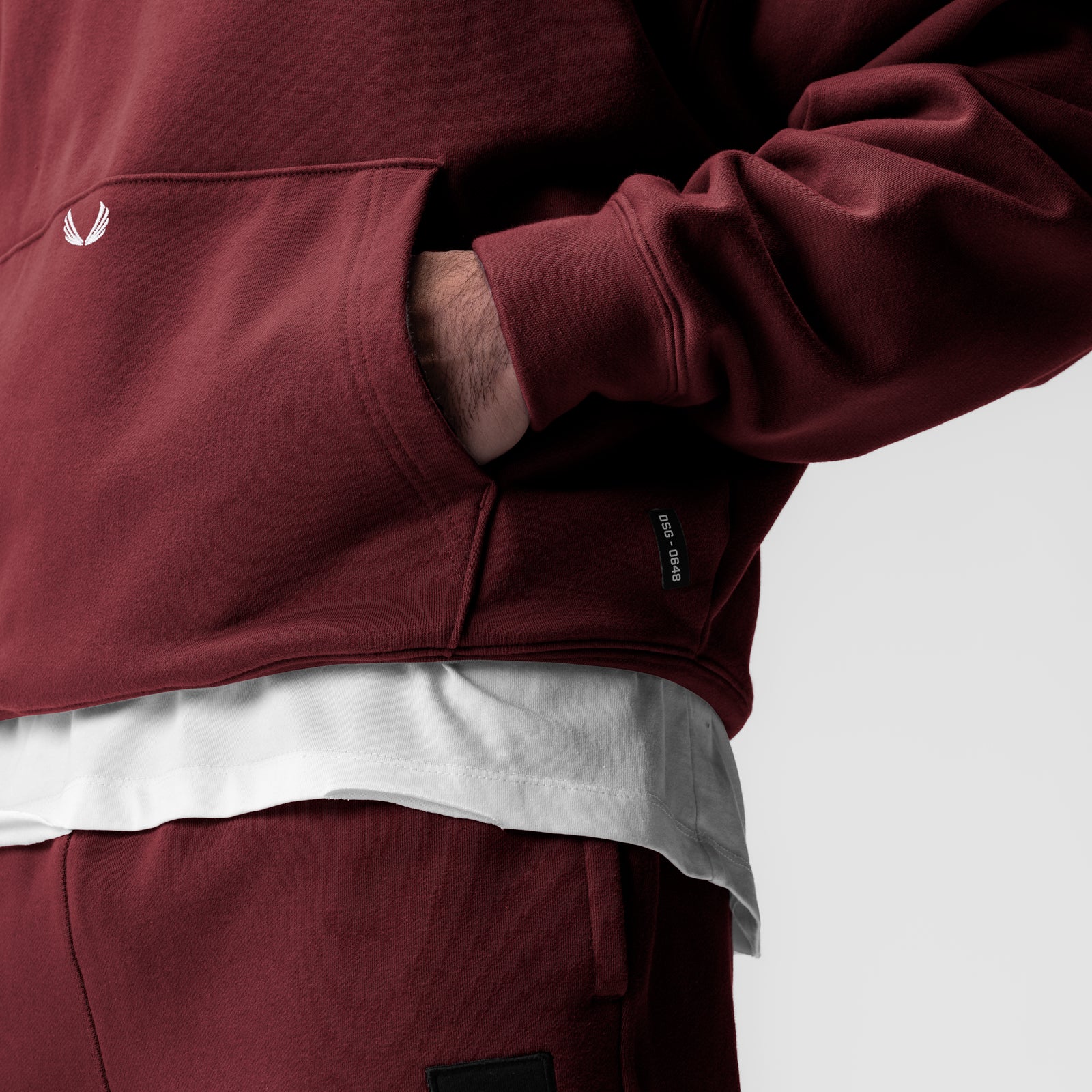 Tech-Terry™ Hoodie in crimson worn by model, layered over white tee, side view