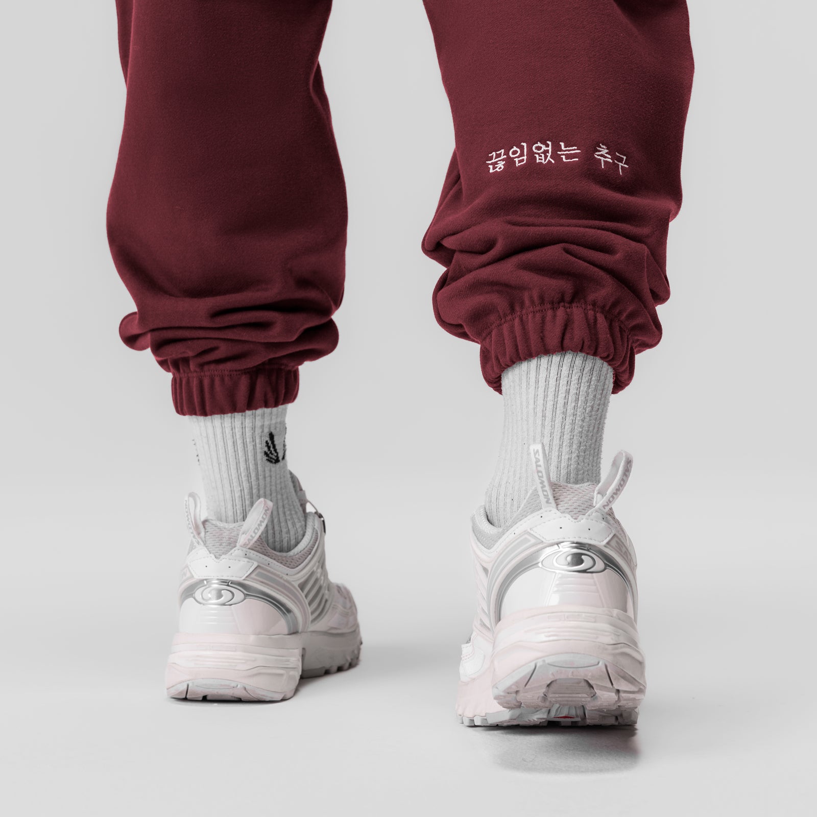 Tech-Terry oversized crimson joggers worn with white socks and sneakers, back view