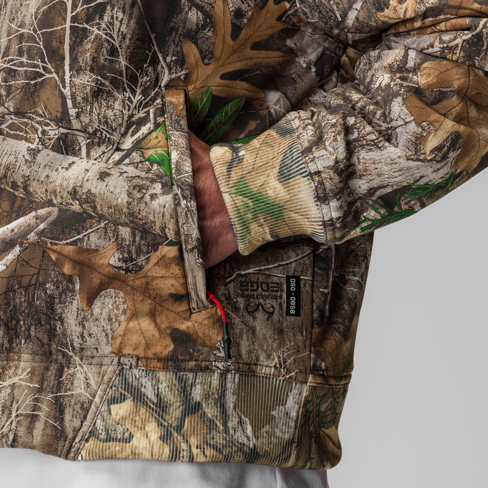 Ripstop Insulated Bomber Jacket in Realtree camo, worn with green striped gloves, detail view