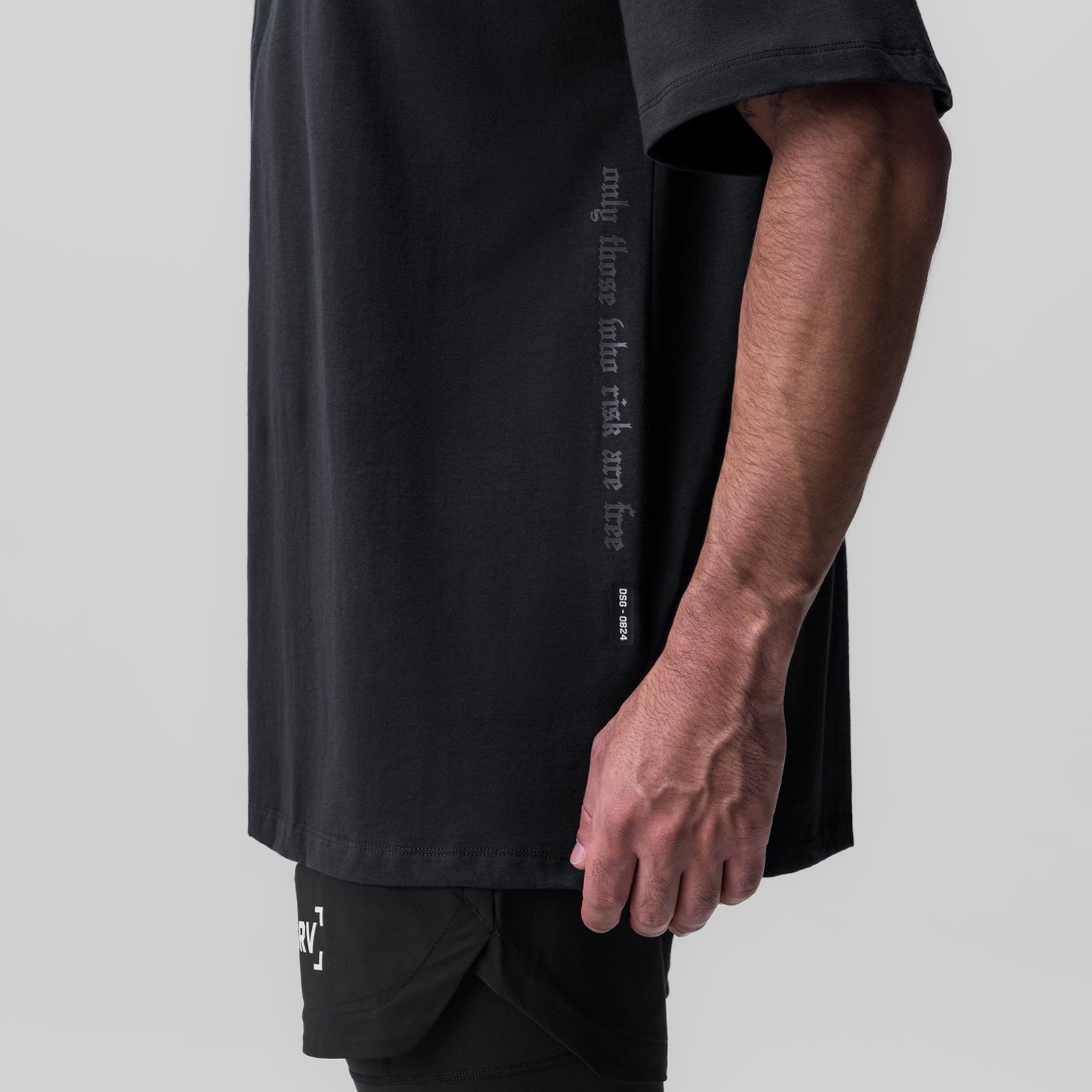 Black Supima oversized tee worn by model, side view showing text graphic
